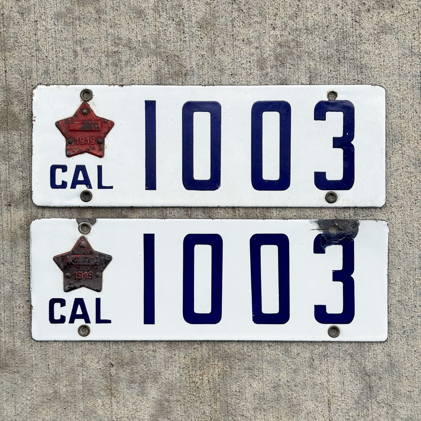 Photo of a 1916 1919 California Porcelain License Plate Pair Auto Tag Garage Decor Vintage Matching Star Badge Low Number Four Digit 1003 with original patina