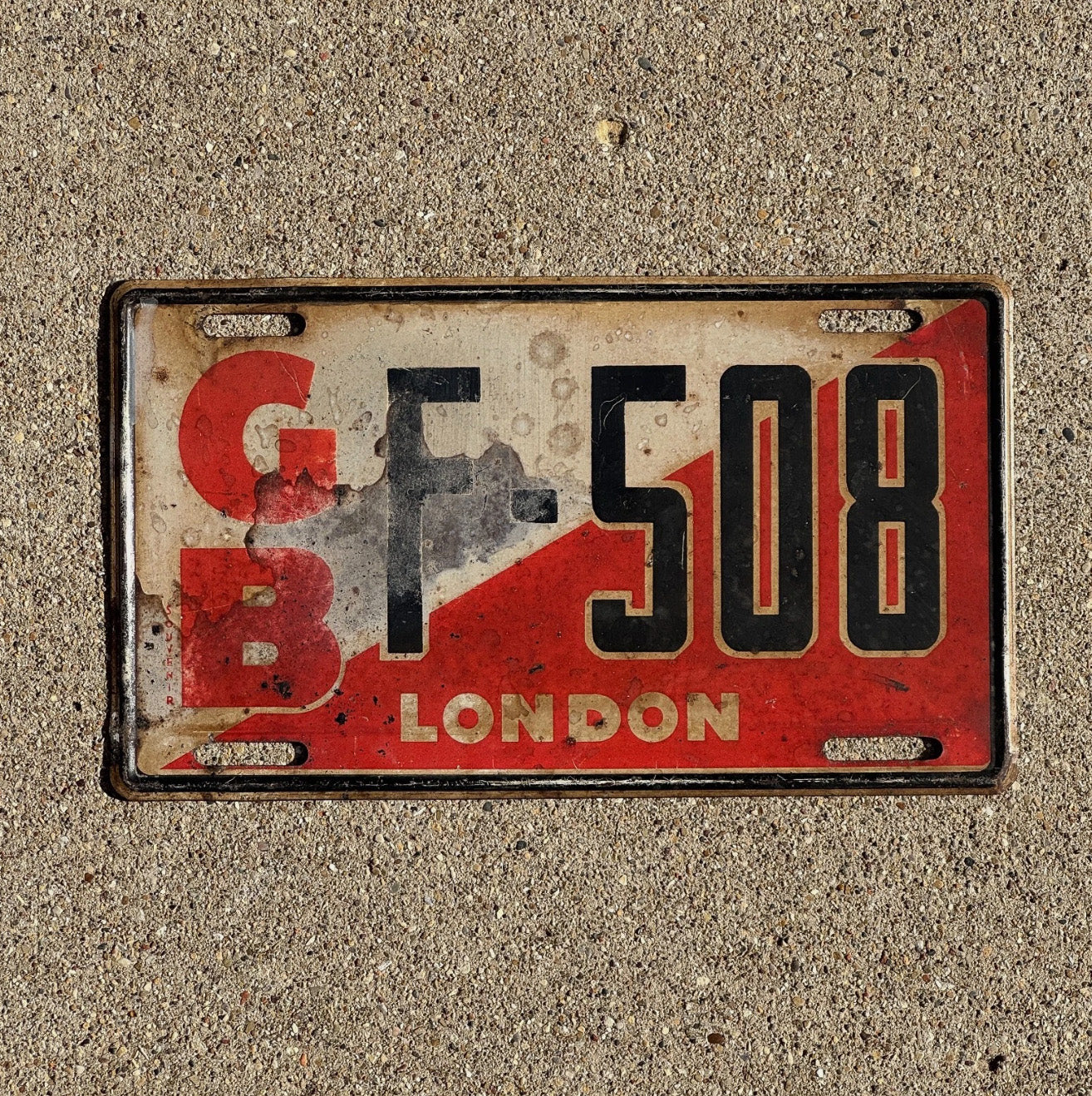 Photo of a 1939 London Globe Trotter Booster License Plate Auto Tag Garage Decor Vintage Globetrotter England UK United Kingdom Britain F 508 with original patina