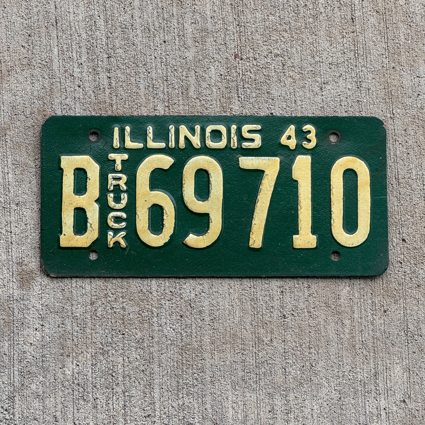 Photo of a 1943 Illinois Truck License Plate Auto Tag Garage Decor Vintage Embossed Text B 69710 with original patina