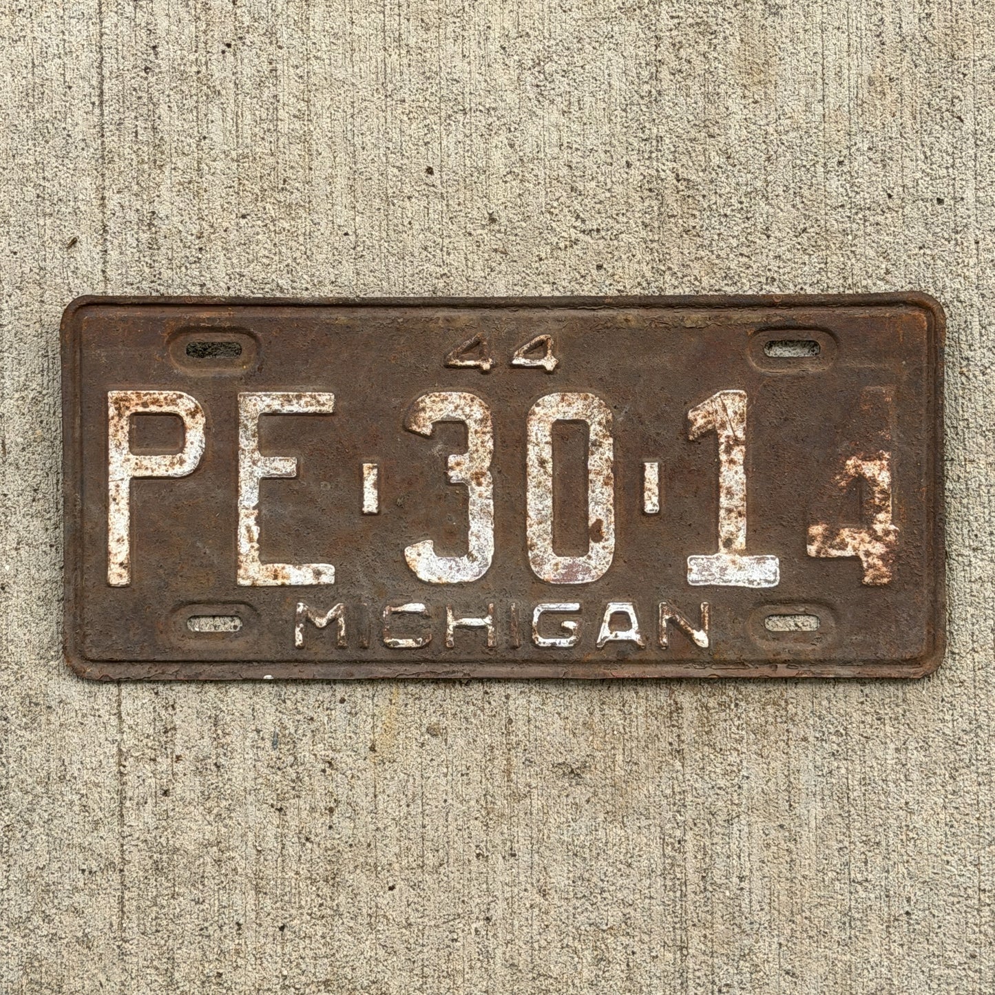 Photo of a 1944 Michigan License Plate Auto Tag Garage Decor Vintage PE 30 14 with original patina