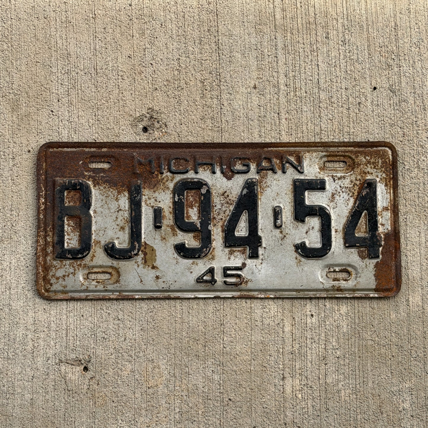 Photo of a 1945 Michigan License Plate Auto Tag Garage Decor Vintage BJ 94 54 with original patina