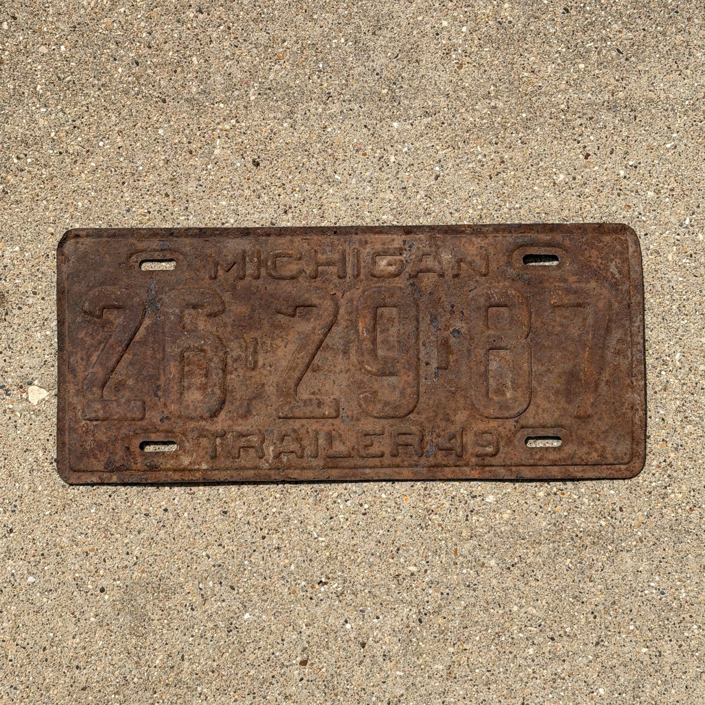 Photo of a 1949 Michigan Trailer License Plate Auto Tag Garage Decor Vintage 26 29 87 with original patina