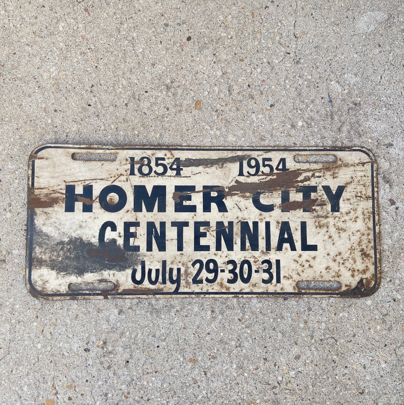 Photo of a 1954 Homer City Pennsylvania Booster License Plate Auto Tag Garage Decor Vintage Metal Centennial with original patina
