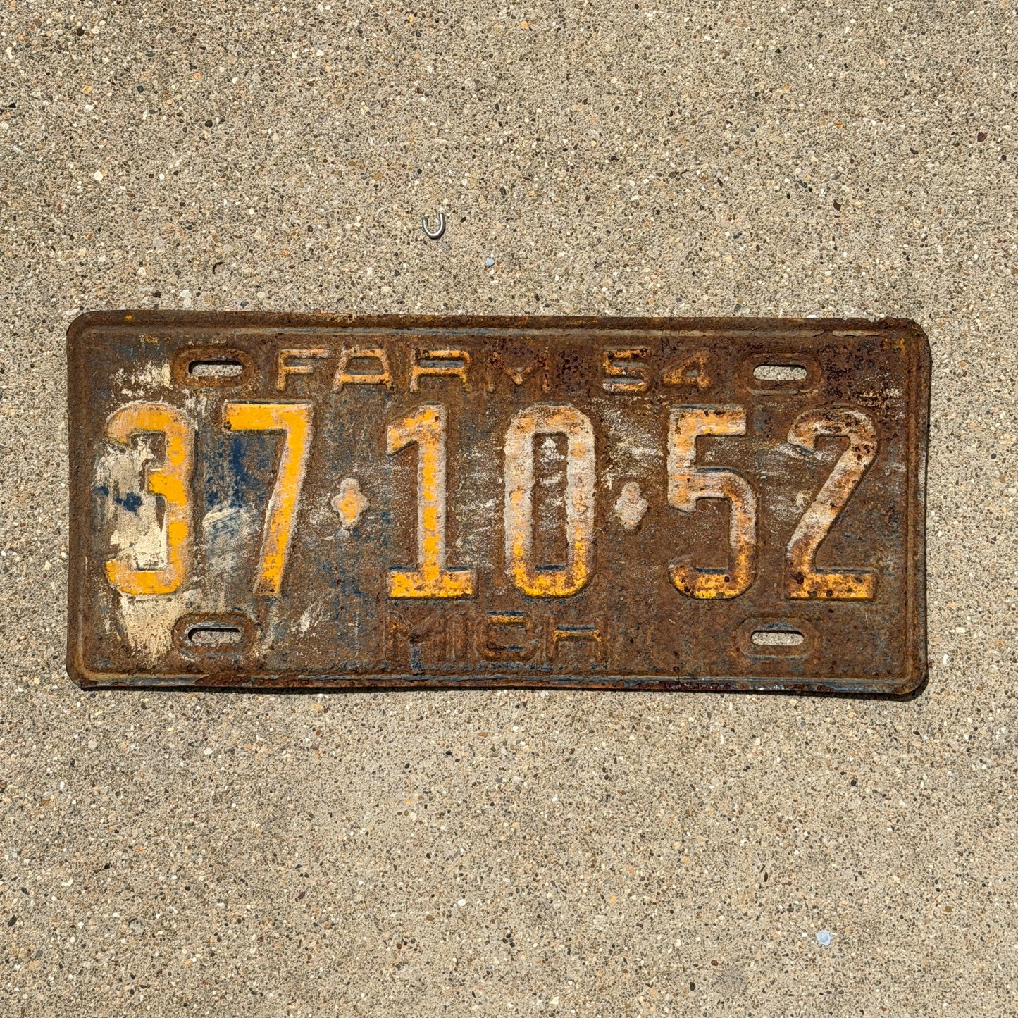 Photo of a 1954 Michigan Farm License Plate Auto Tag Garage Decor Vintage 37 10 52 with original patina