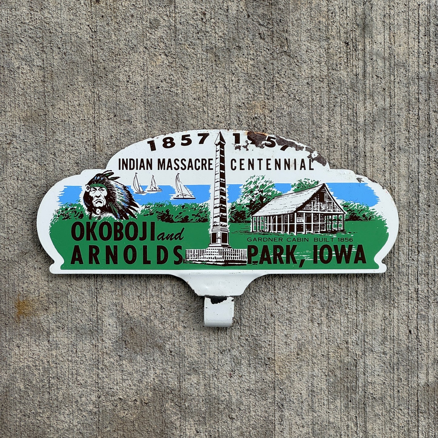 Photo of a 1957 Indian Massacre Centennial Arnolds Park Iowa License Plate Topper Auto Tag Garage Decor Vintage Okoboji with original patina