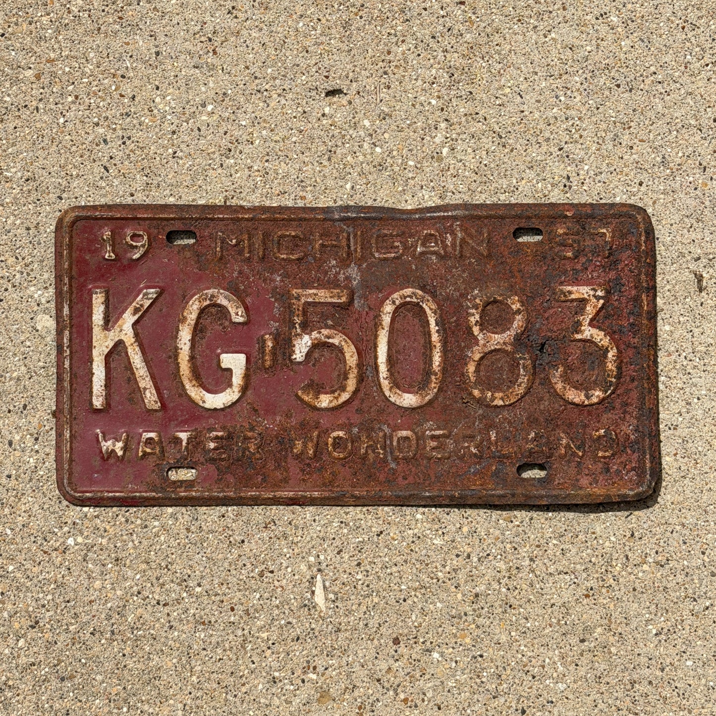 Photo of a 1957 Michigan License Plate Auto Tag Garage Decor Vintage KG 5083 with original patina