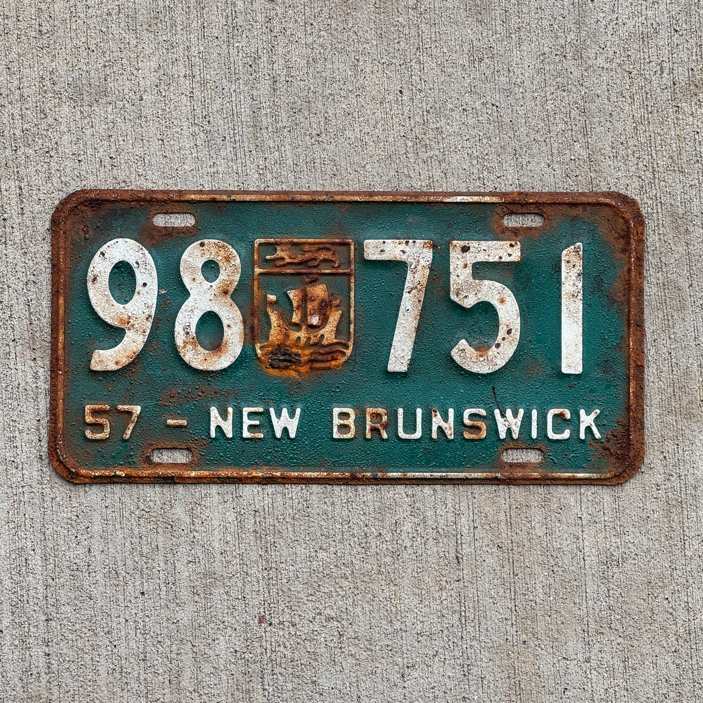 Photo of a 1957 New Brunswick License Plate Auto Tag Garage Decor Vintage Provincial Coat of Arms 98 751 with original patina