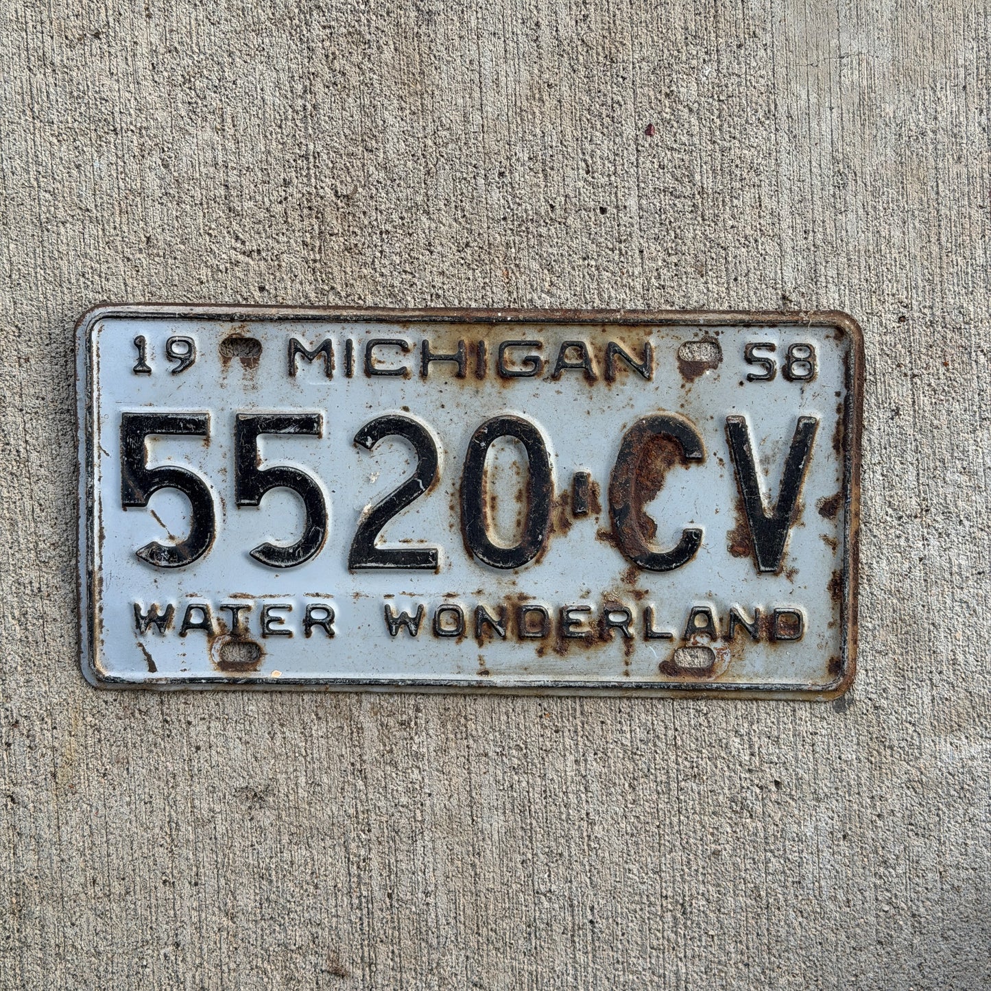 Photo of a 1958 Michigan Commercial License Plate Auto Tag Garage Decor Vintage 5520 CV with original patina