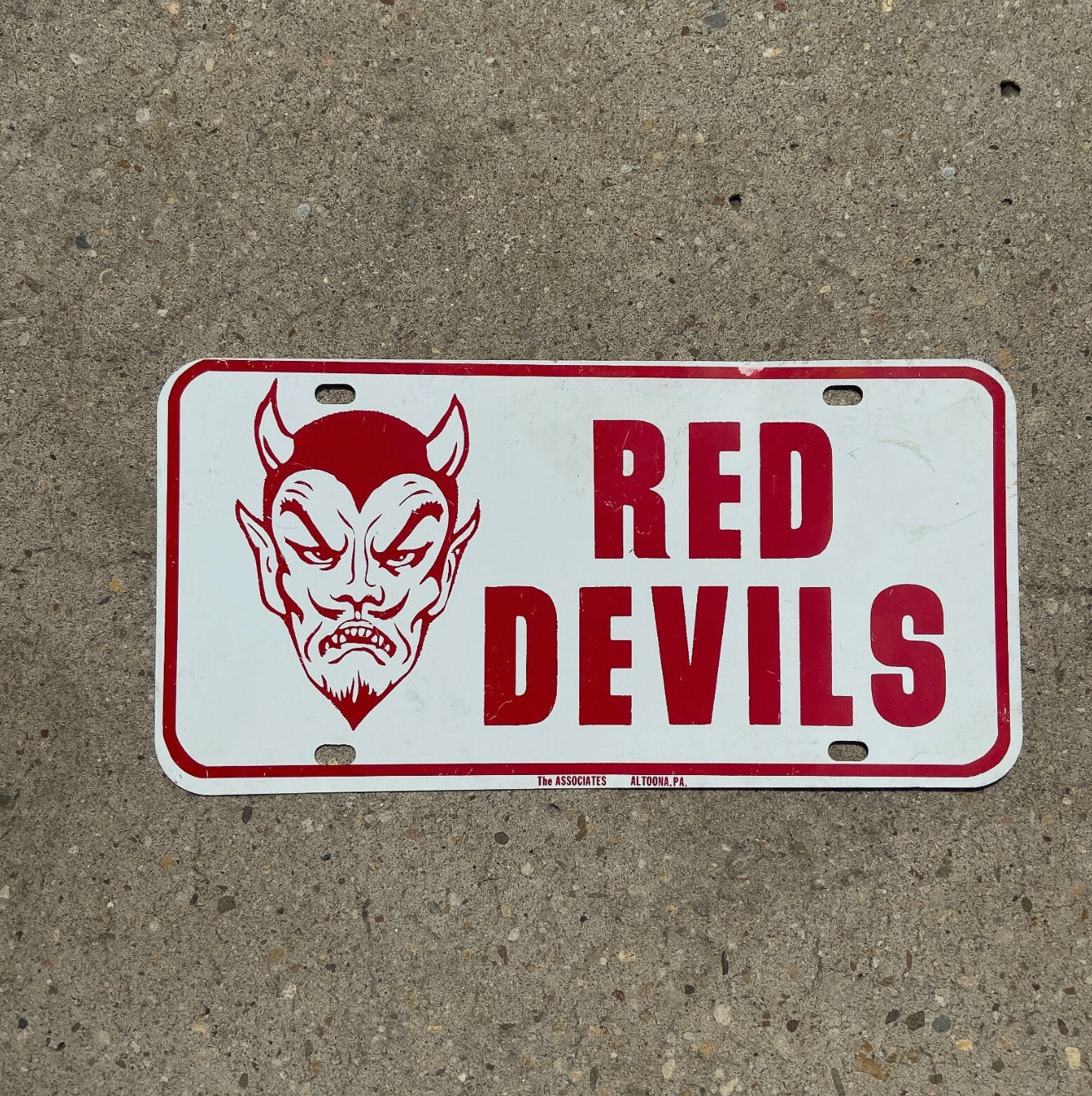 Photo of a 1960 Era Red Devils Booster License Plate Auto Tag Garage Decor Vintage High School Booster Metal 666 Evil with original patina