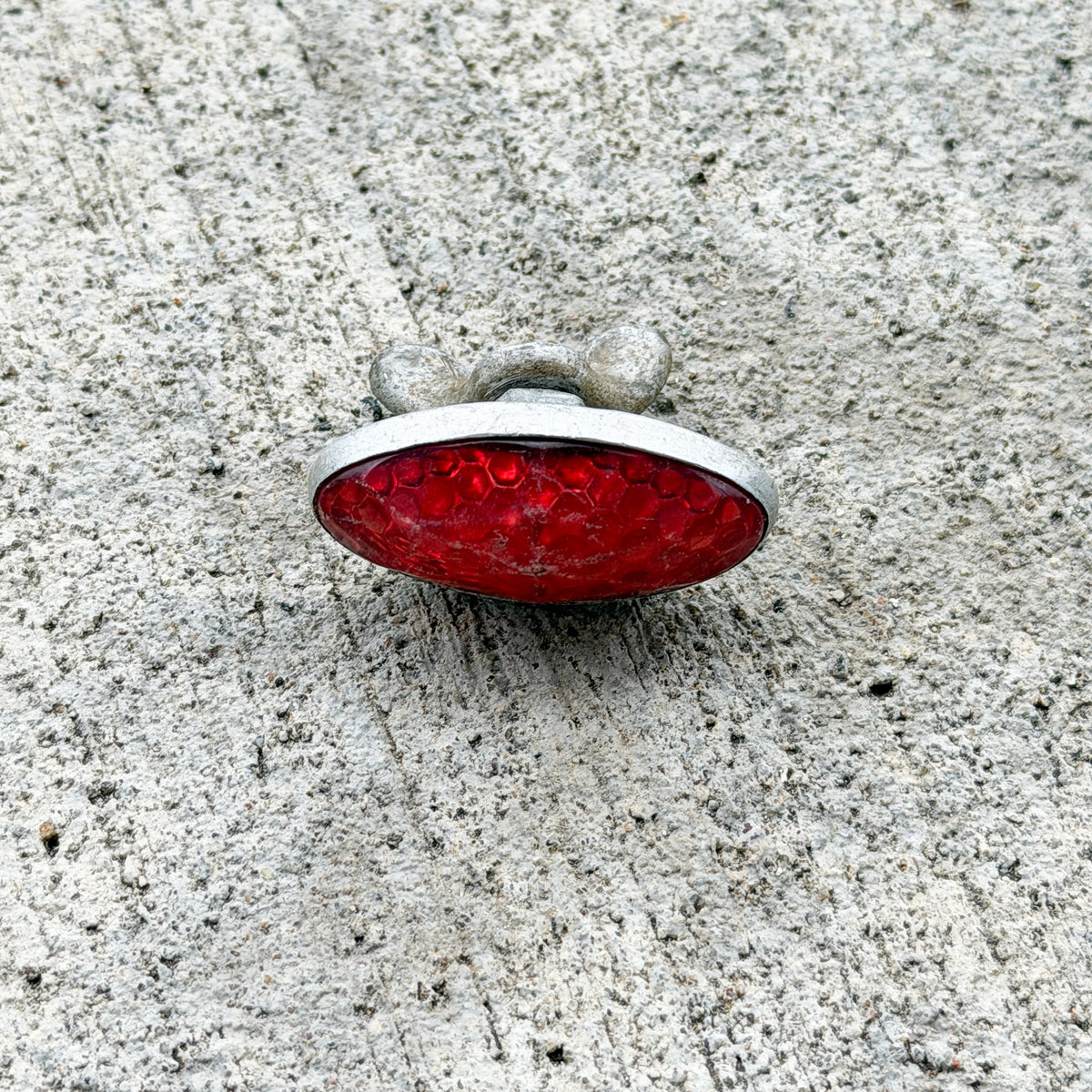 Photo of a 1960 Era Red Jewel Auto Tag Garage Decor Vintage Reflector Plastic Oval Bike Motorcycle Car with original patina