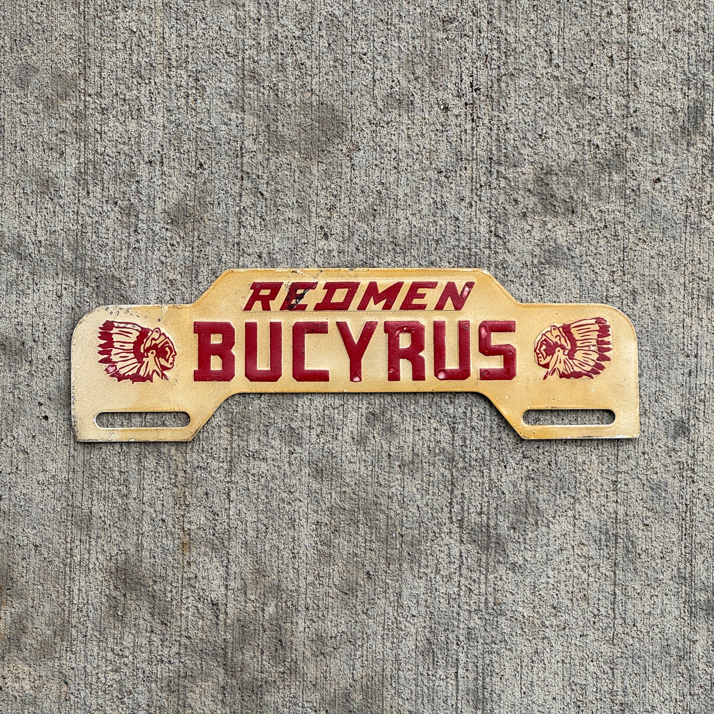 Photo of a 1960 Era Redmen Bucyrus Ohio License Plate Topper Auto Tag Garage Decor Vintage High School with original patina