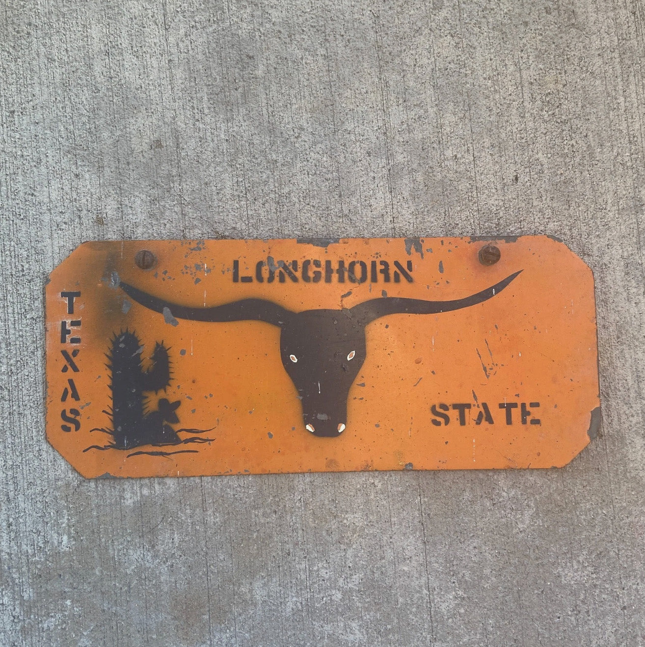 Photo of a 1960 Era Texas Booster License Plate Auto Tag Garage Decor Vintage Cattle Cow Orange Black University with original patina