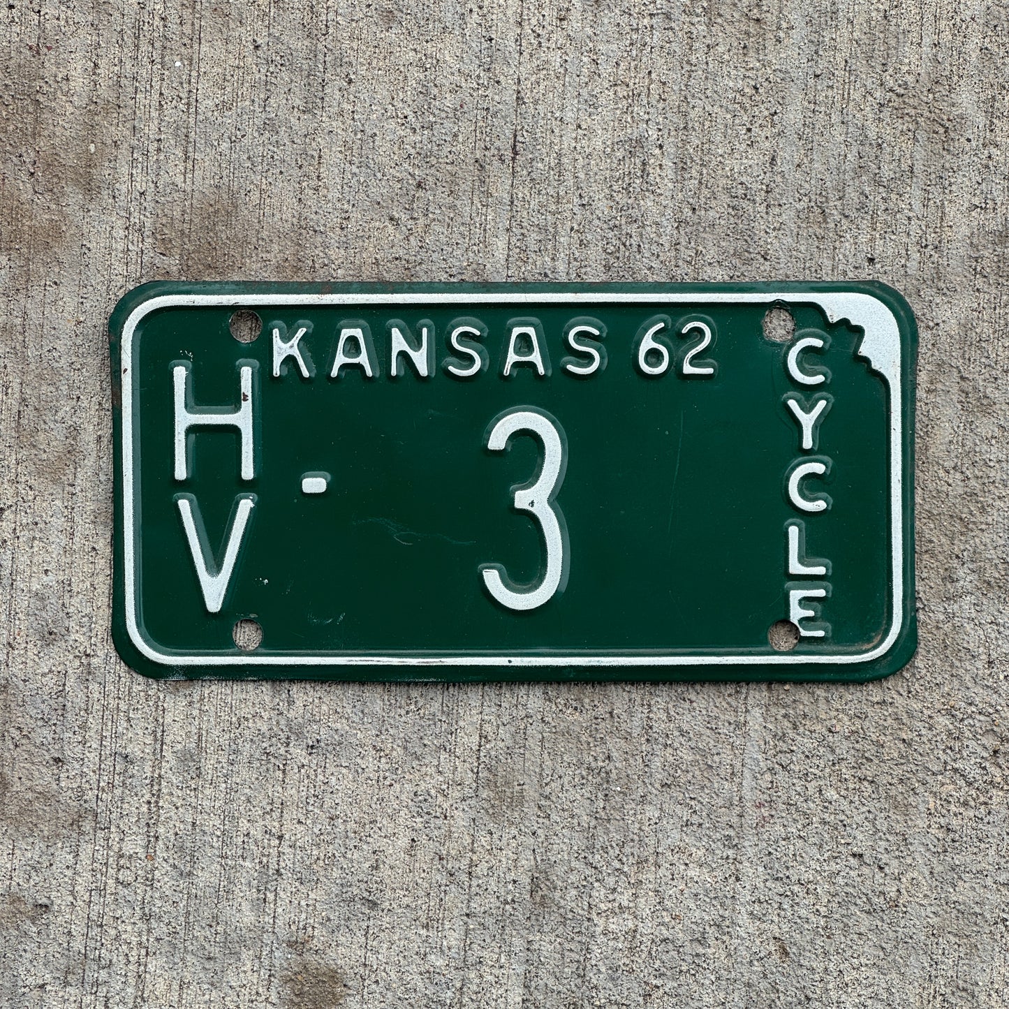 Photo of a 1962 Kansas Motorcycle License Plate Auto Tag Garage Decor Vintage Low Number Single Digit Harvey County HV 3 with original patina