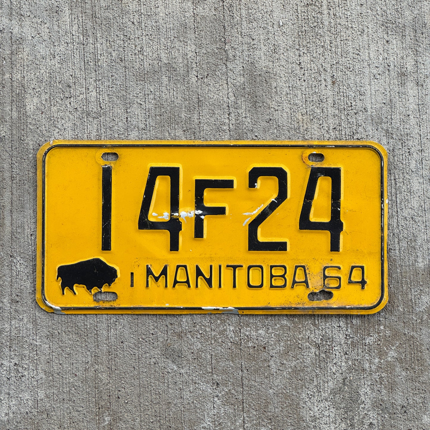 Photo of a 1964 Manitoba License Plate Auto Tag Garage Decor Vintage Buffalo Bison 14 F 24 with original patina