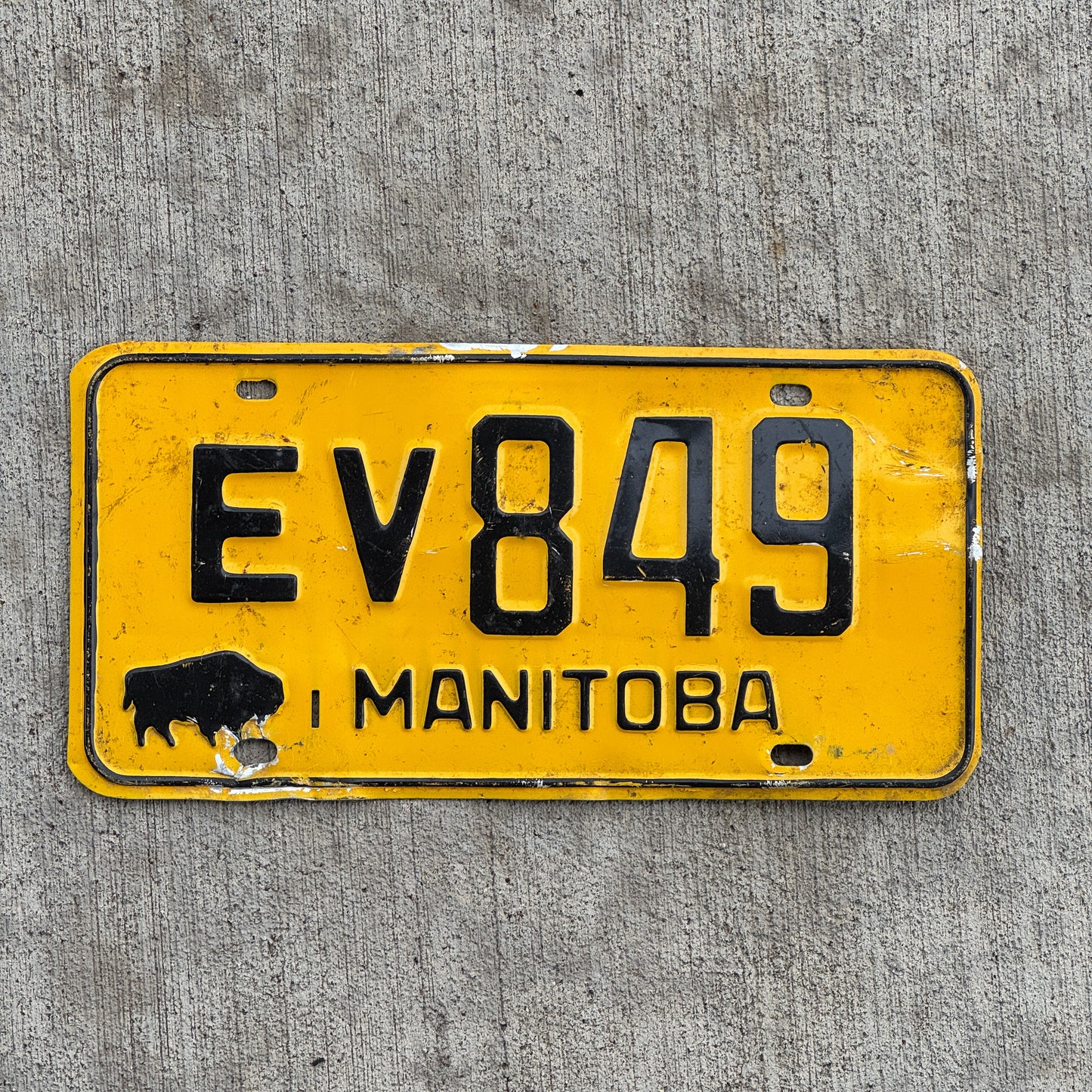 Photo of a 1964 Manitoba License Plate Auto Tag Garage Decor Vintage Buffalo Bison EV 849 with original patina