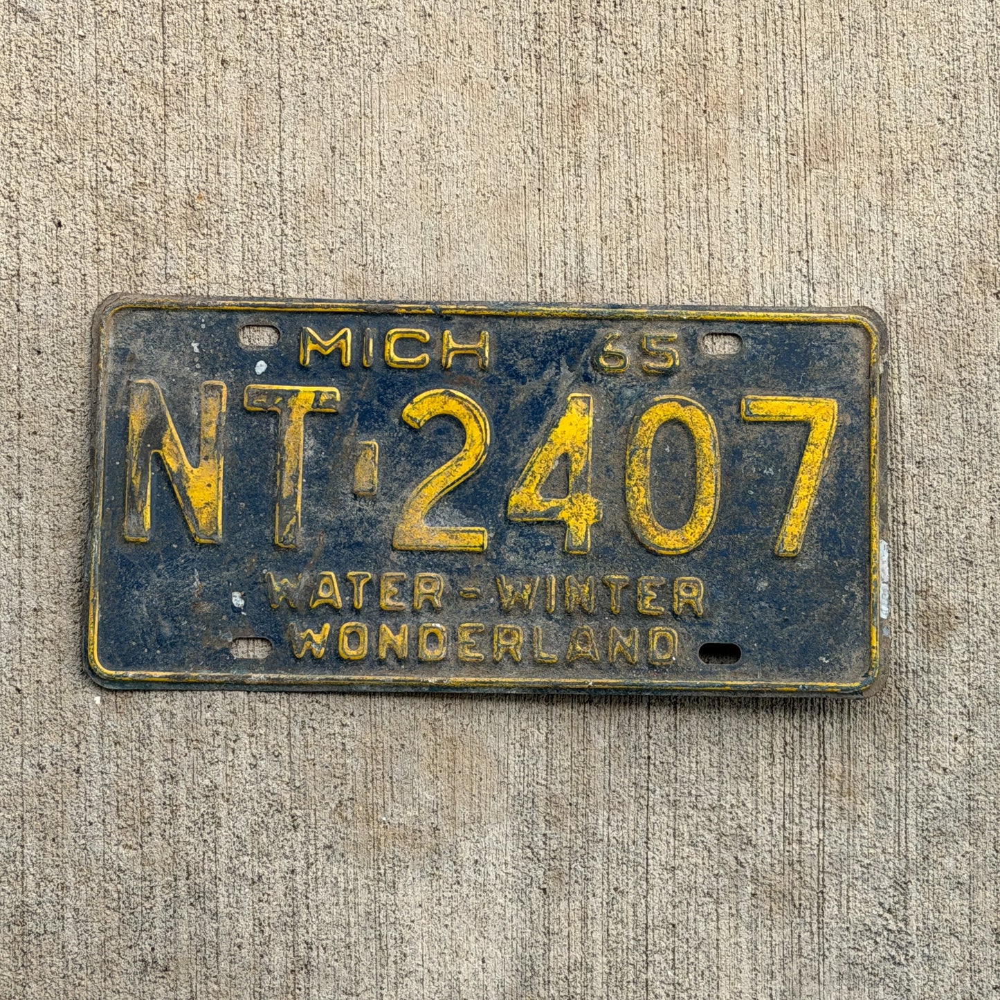 Photo of a 1965 Michigan License Plate Auto Tag Garage Decor Vintage NT 2407 with original patina