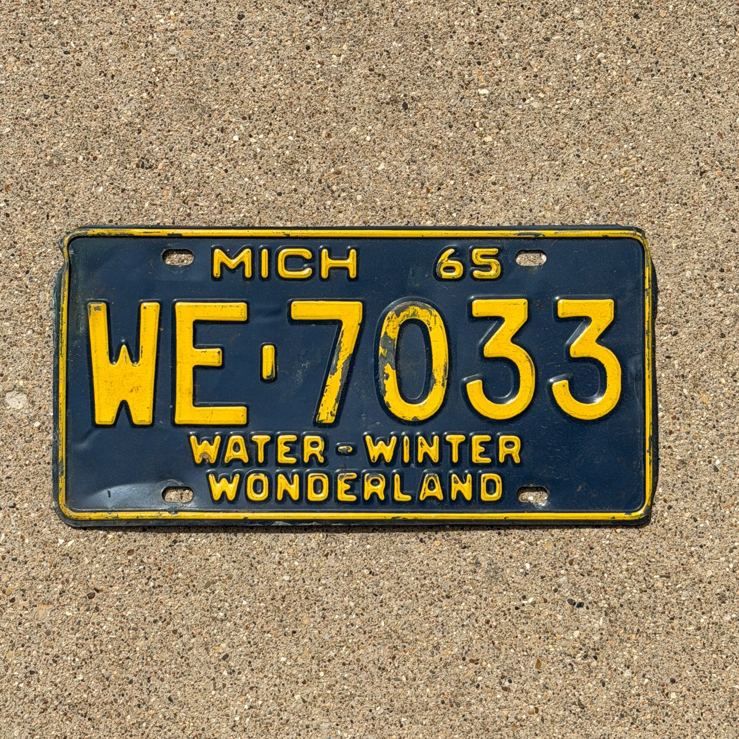 Photo of a 1965 Michigan License Plate Auto Tag Garage Decor Vintage WE 7033 with original patina
