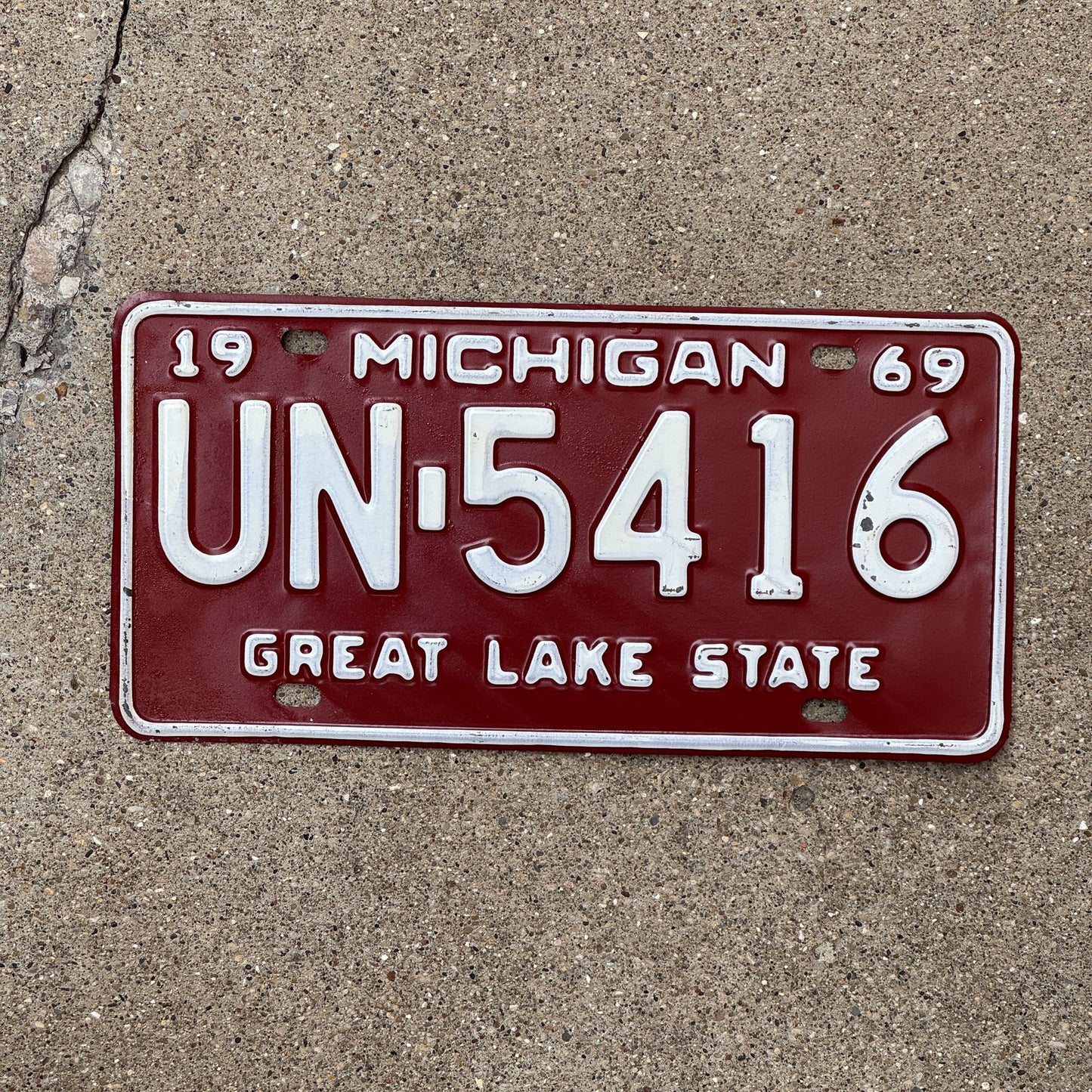 Photo of a 1969 Michigan License Plate Auto Tag Garage Decor Vintage Red White UN 5416