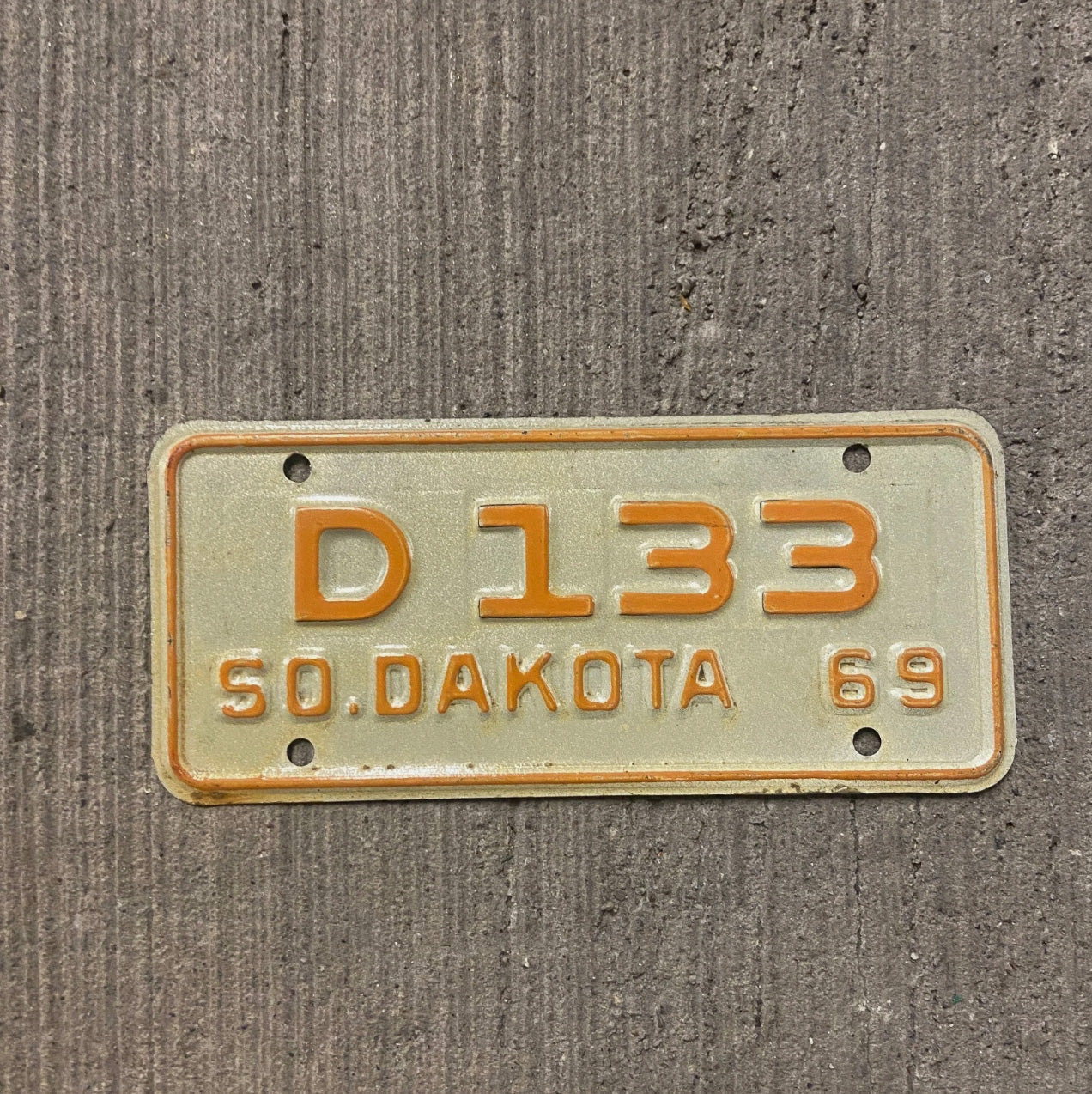 Photo of a 1969 South Dakota Motorcycle Dealer License Plate Auto Tag Garage Decor Vintage D 133 with original patina