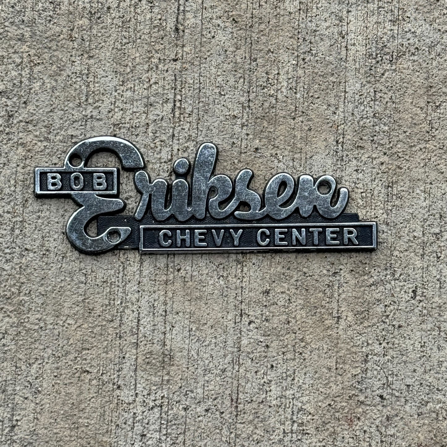 Photo of a 1970 Era Bob Eriksen Milan Illinois Dealer Badge Emblem Auto Tag Garage Decor Vintage Chevy Dealership with original patina