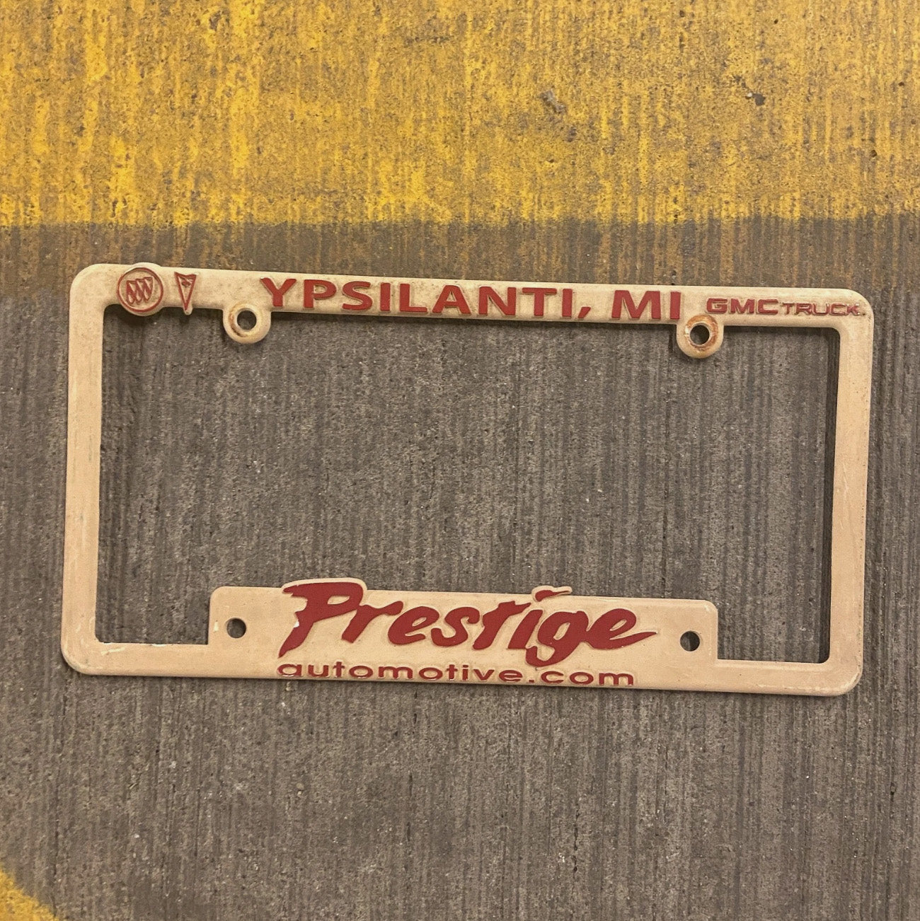 Photo of a 1970 Era Michigan License Plate Frame Auto Tag Garage Decor Vintage Ypsilanti Plastic GMC Prestige