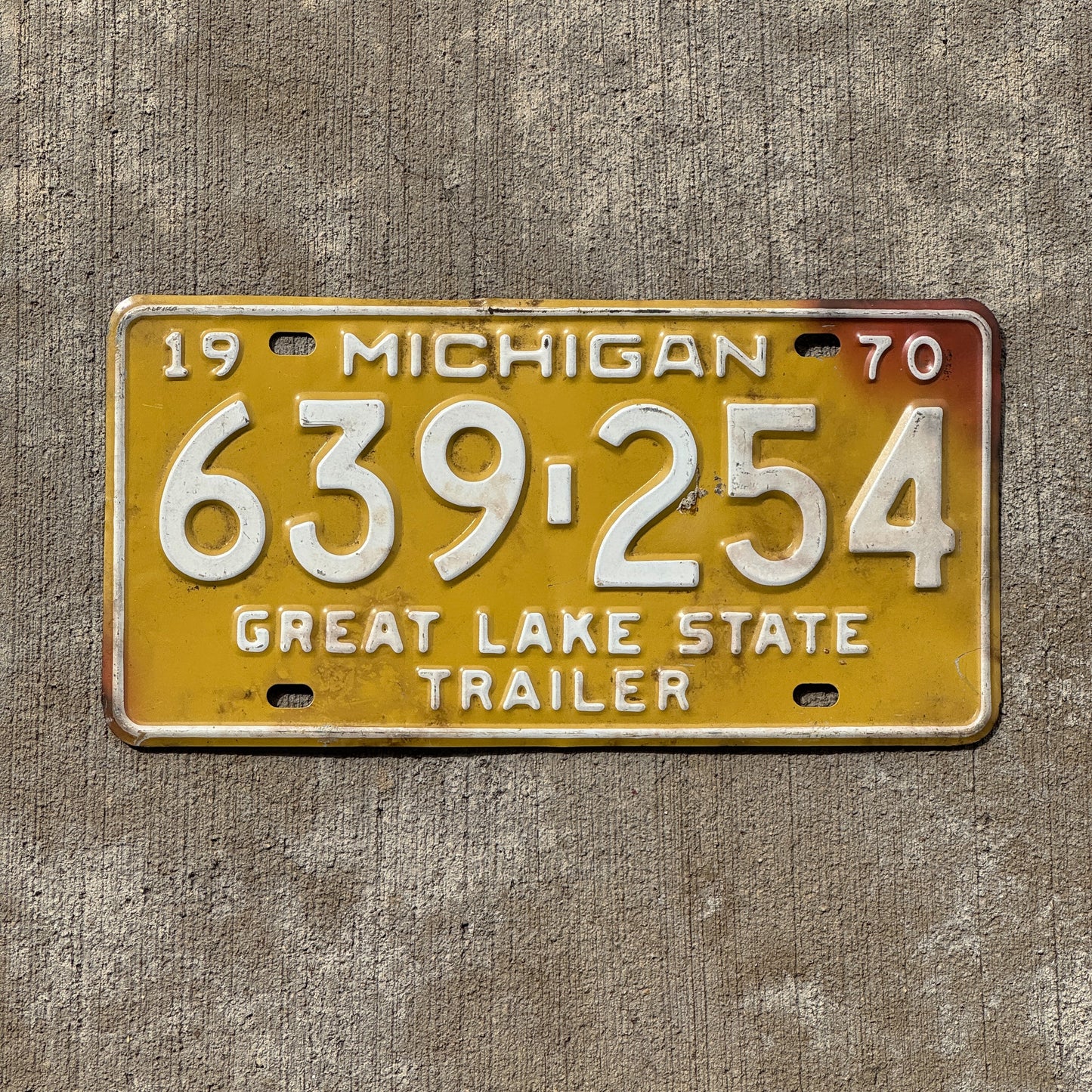 Photo of a 1970 Michigan Trailer License Plate Auto Tag Garage Decor Vintage 639 254 with original patina