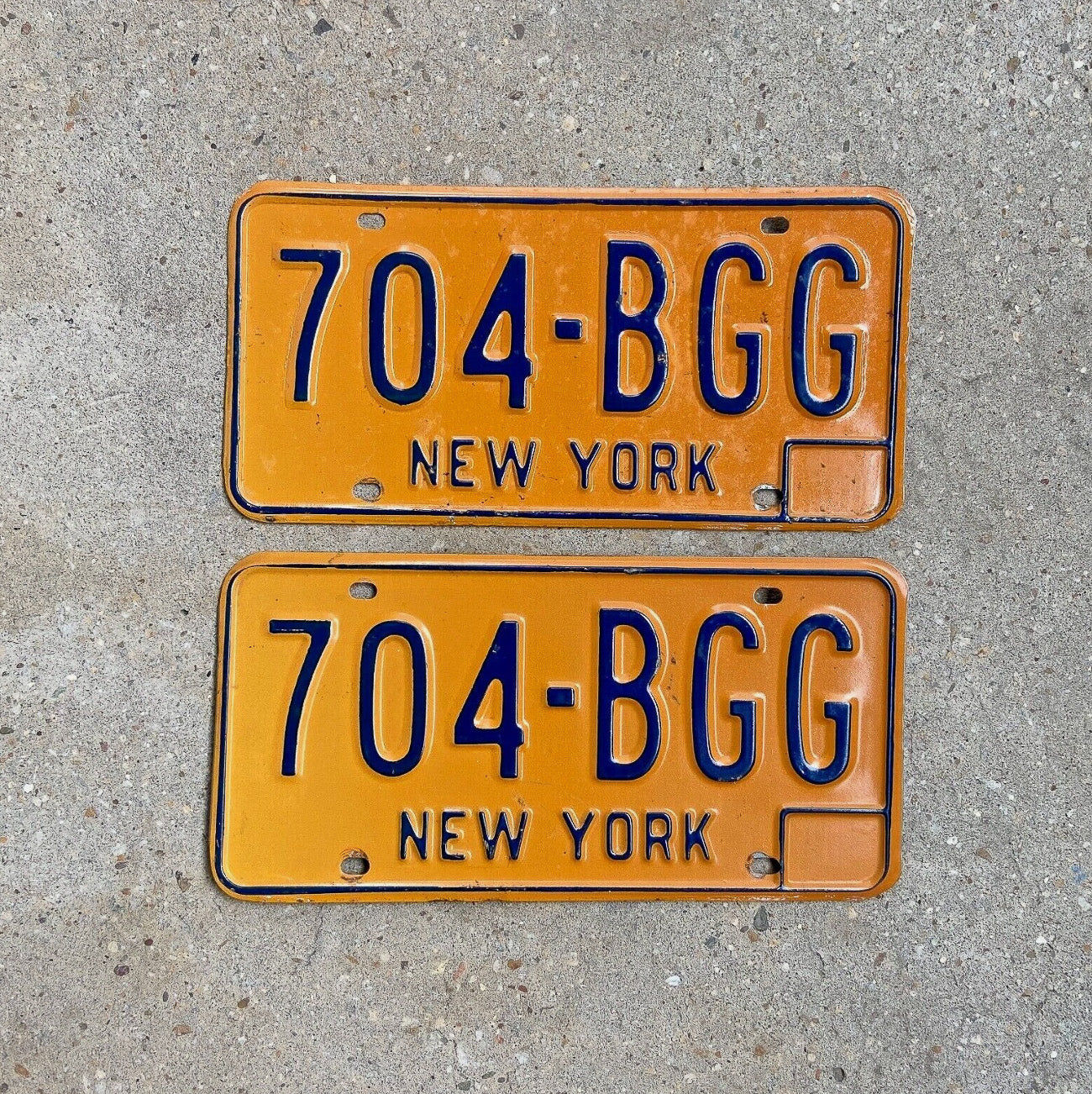 Photo of a 1973 1986 New York License Plate Pair Auto Tag Garage Decor Vintage YOM DMV Clear 704 BGG with original patina