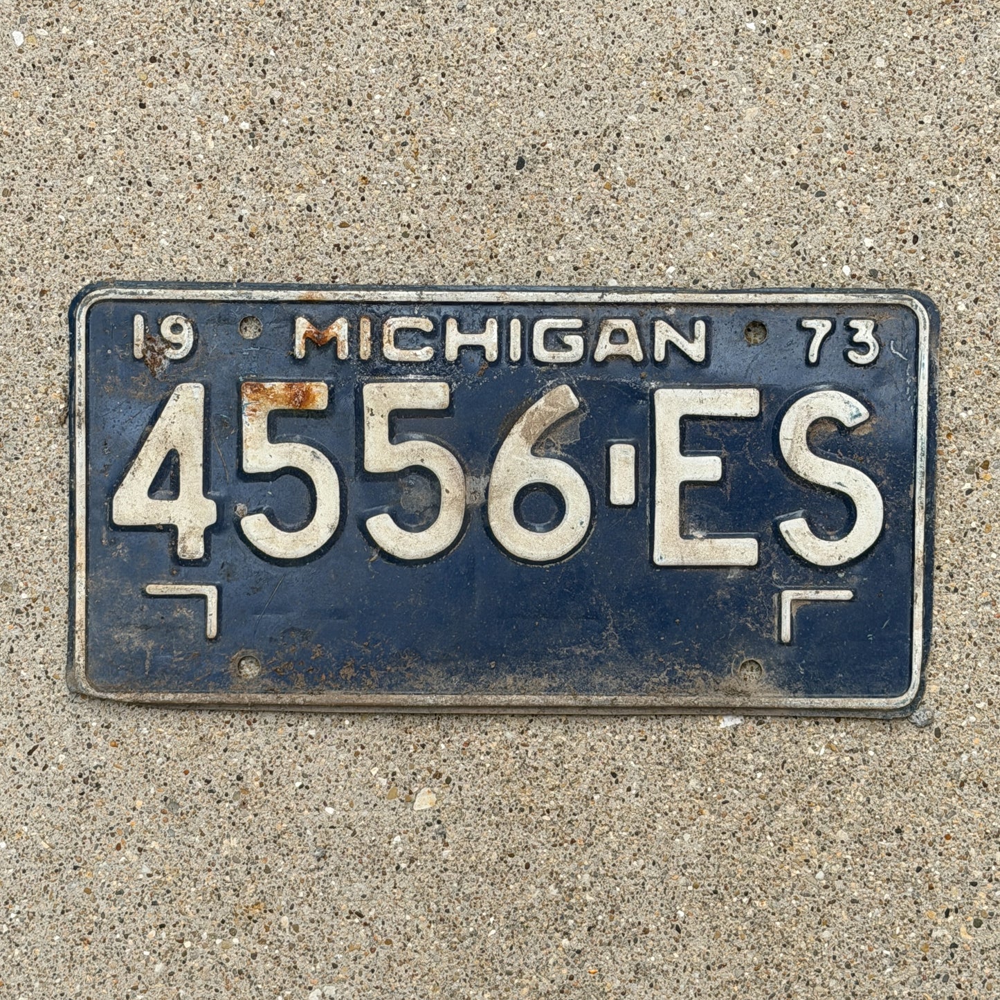 Photo of a 1973 Michigan Commercial License Plate Auto Tag Garage Decor Vintage 4556 ES with original patina