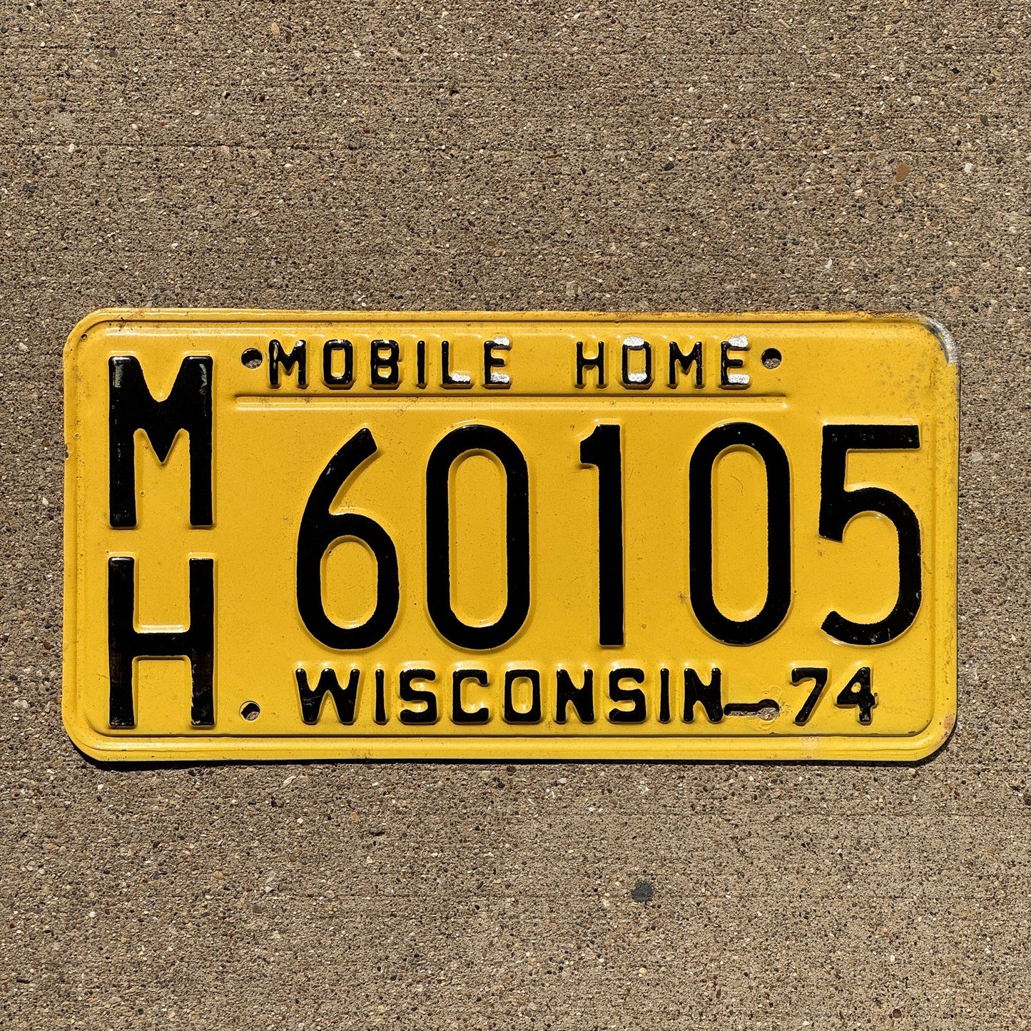 Photo of a 1974 Wisconsin Mobile Home License Plate Auto Tag Garage Decor Vintage MH 60105