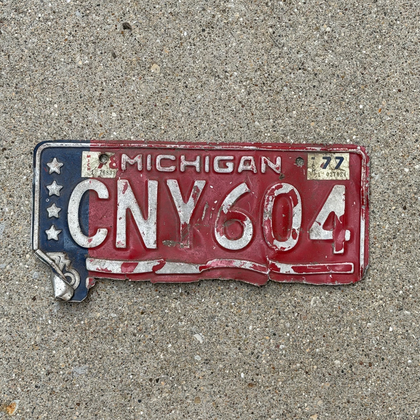 Photo of a 1976 1977 Michigan License Plate Auto Tag Garage Decor Vintage Bicentennial CNV 604 with original patina