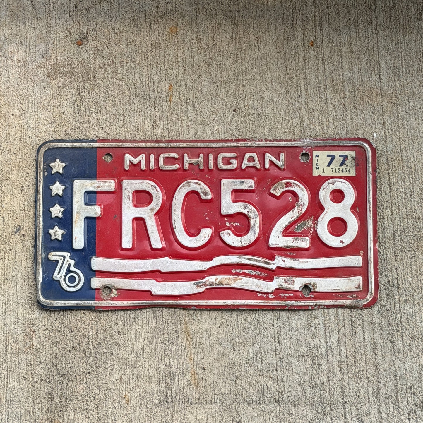 Photo of a 1976 1977 Michigan License Plate Auto Tag Garage Decor Vintage Bicentennial FRC 528 with original patina