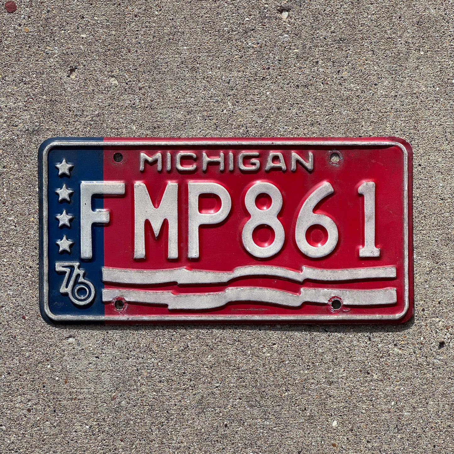 Photo of a 1976 Michigan License Plate Auto Tag 2 Vintage Garage American Flag Bicentennial FMP 861 with original patina