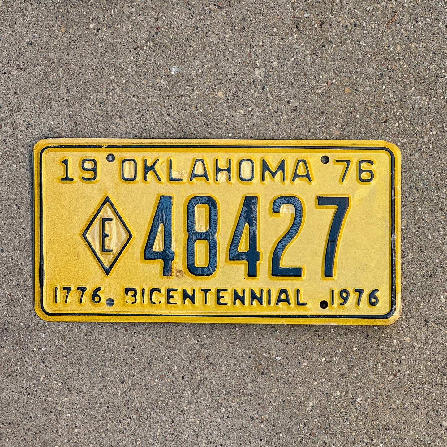 Photo of a 1976 Oklahoma Exempt License Plate Auto Tag Garage Decor Vintage Diamond E Fire State Police 48427 with original patina
