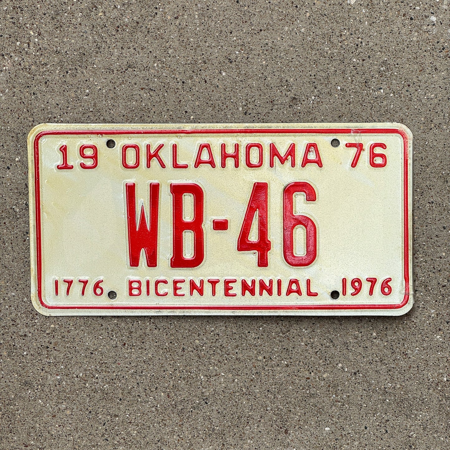 Photo of a 1976 Oklahoma License Plate Auto Tag Garage Decor Vintage Bicentennial Low Number Two Digit WB 46 with original patina