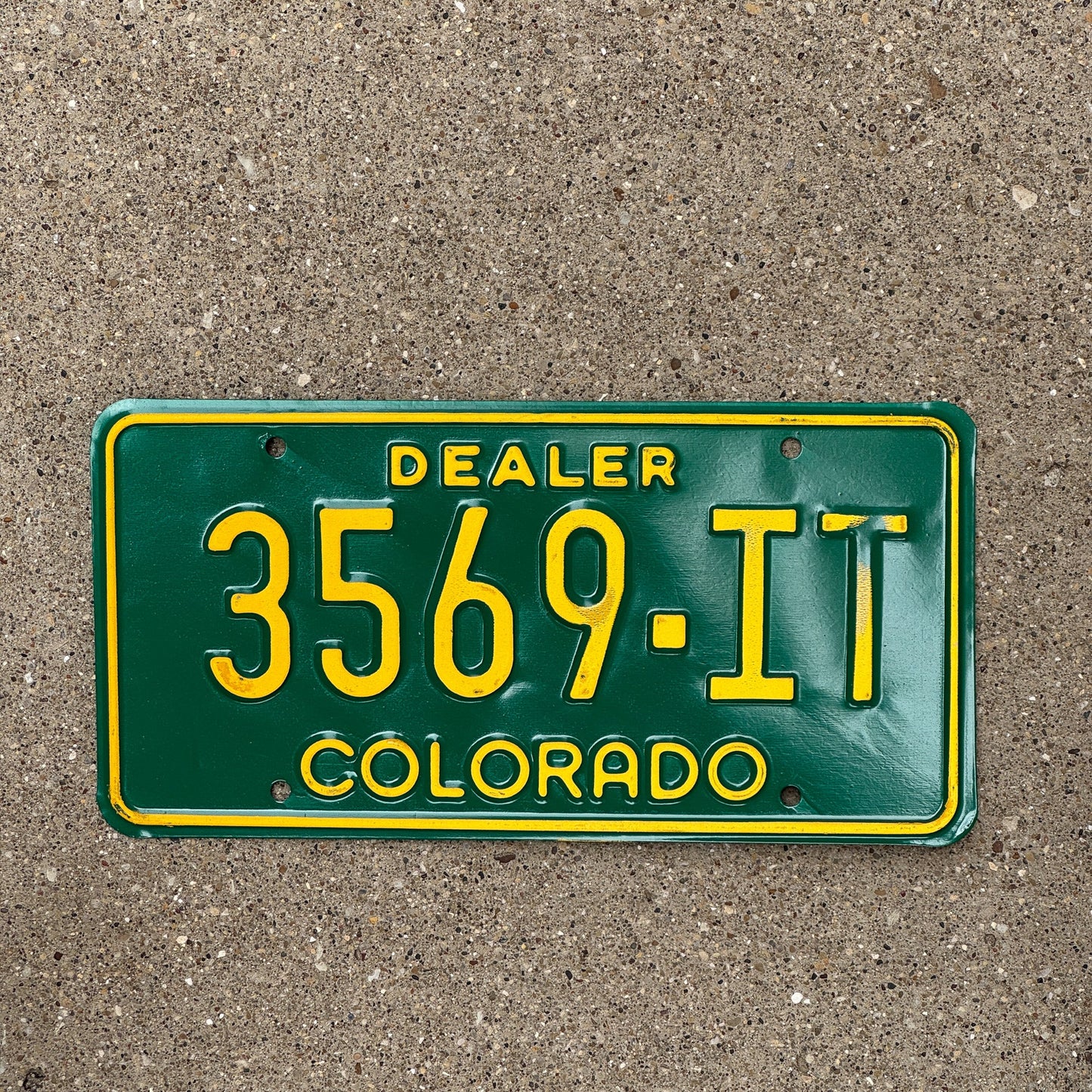 Photo of a 1977 Colorado Dealer License Plate Auto Tag Garage Decor Vintage Yellow Text Type 3569 IT