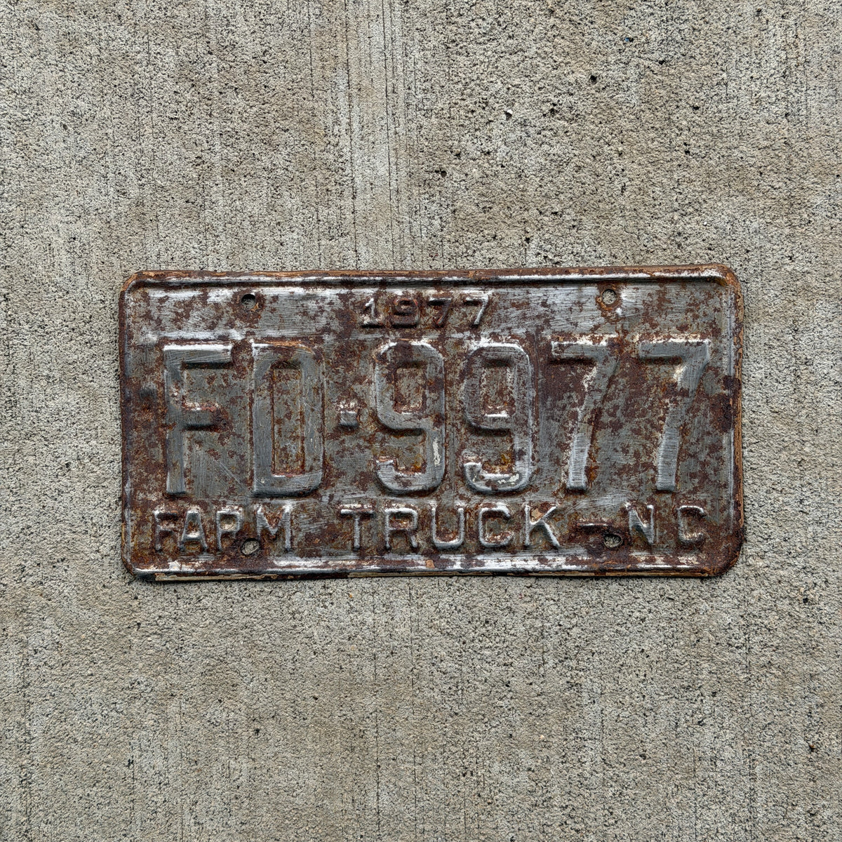 Photo of a 1977 North Carolina Farm Truck License Plate Auto Tag Garage Decor Vintage FD 9977 with original patina