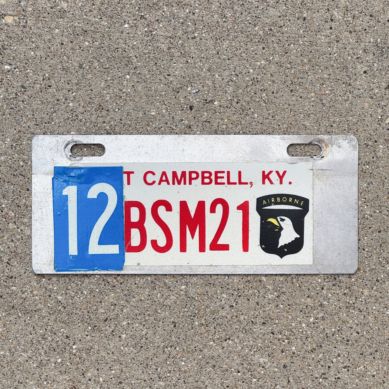 Photo of a 1980 Era Fort Campbell Kentucky License Plate Topper Auto Tag Garage Decor Vintage Decal 101st Airborne 12 BSM 21 with original patina