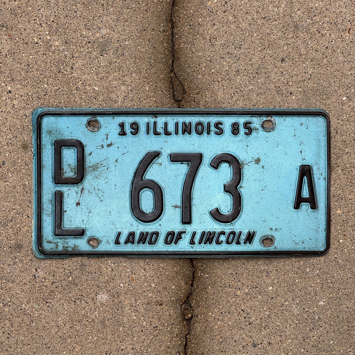 Photo of a 1985 Illinois Dealer License Plate Auto Tag 1 Vintage Garage Merritt's Sterling Ford Mercury Lincoln Dealer 673 A with original patina
