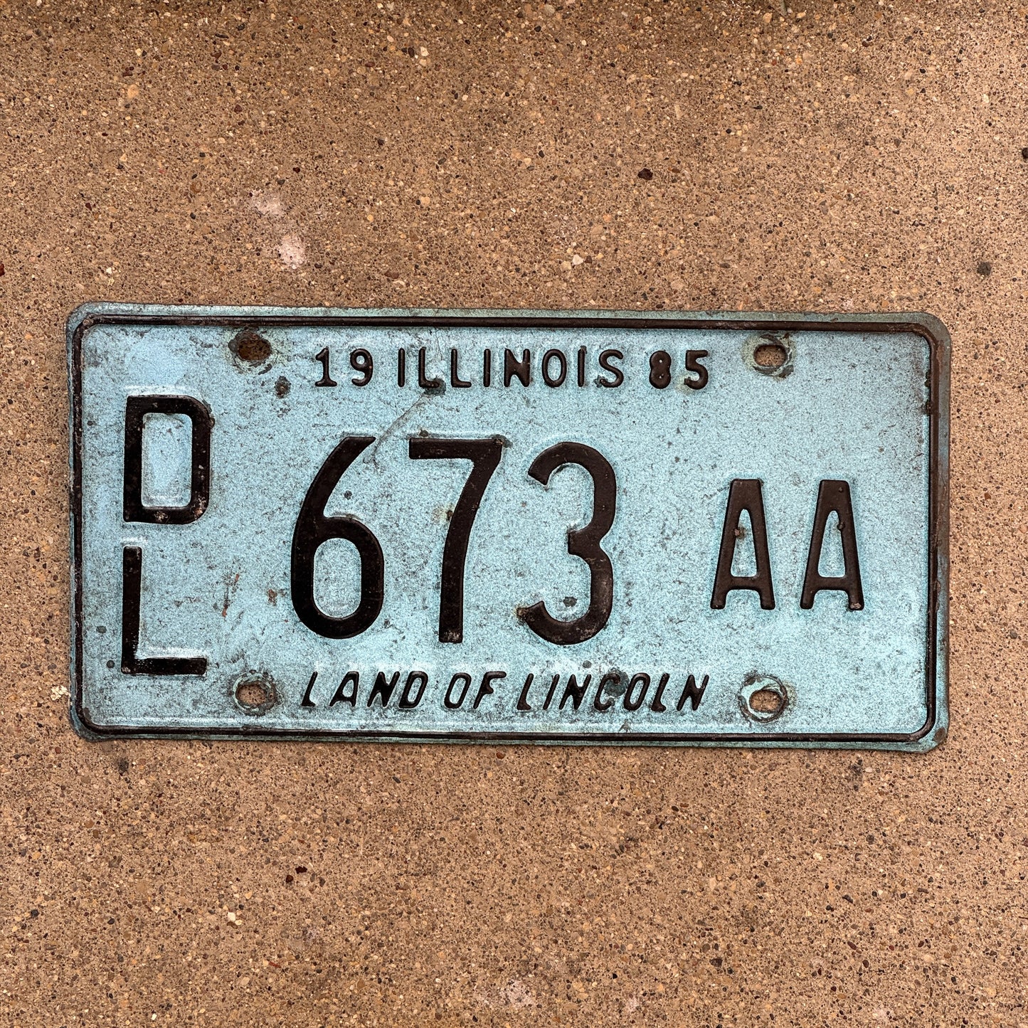 Photo of a 1985 Illinois Dealer License Plate Auto Tag 1 Vintage Garage Merritt's Sterling Ford Mercury Lincoln Dealer 673 AA with original patina
