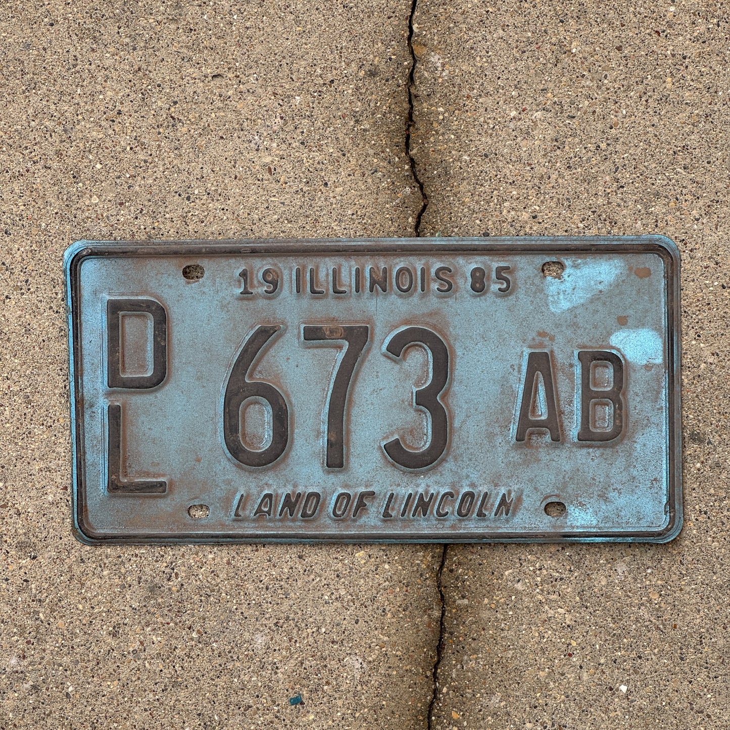 Photo of a 1985 Illinois Dealer License Plate Auto Tag 1 Vintage Garage Merritt's Sterling Ford Mercury Lincoln Dealer 673 AB with original patina
