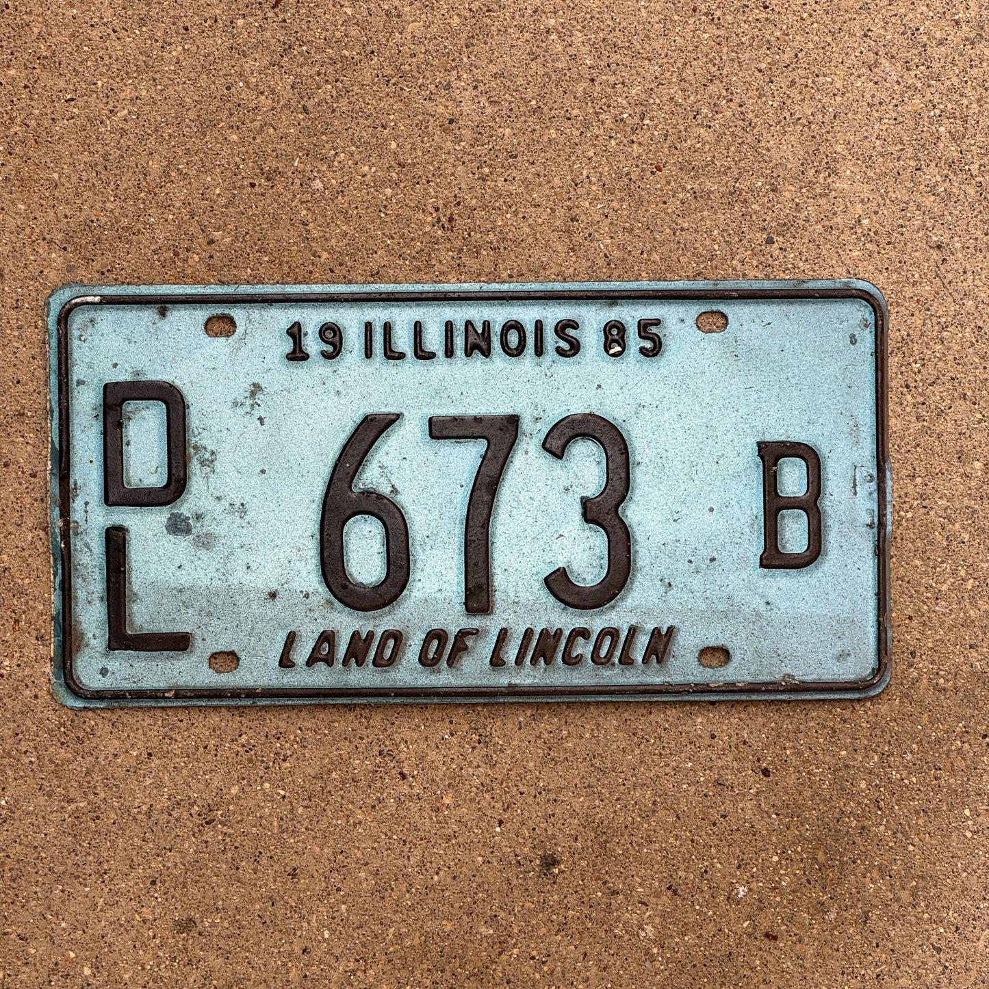 Photo of a 1985 Illinois Dealer License Plate Auto Tag 1 Vintage Garage Merritt's Sterling Ford Mercury Lincoln Dealer 673 B with original patina
