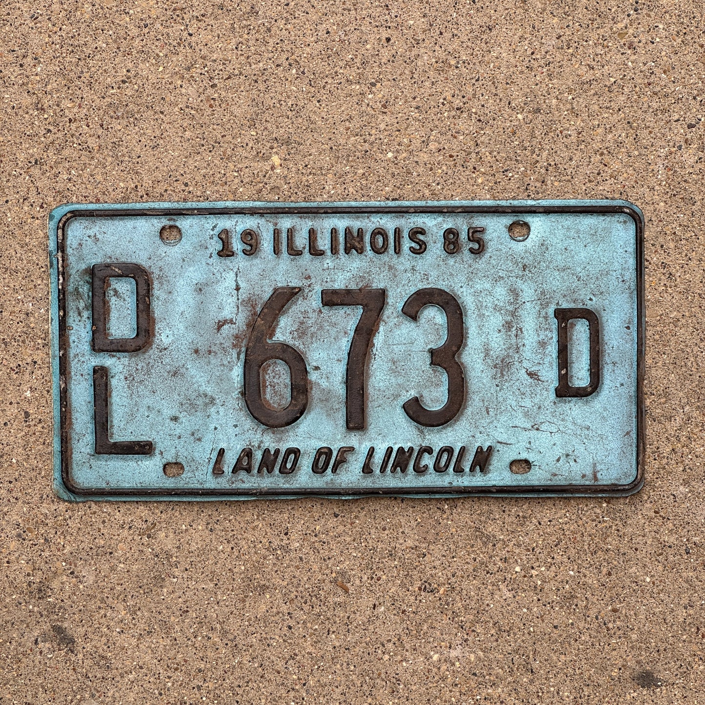 Photo of a 1985 Illinois Dealer License Plate Auto Tag 1 Vintage Garage Merritt's Sterling Ford Mercury Lincoln Dealer 673 D with original patina