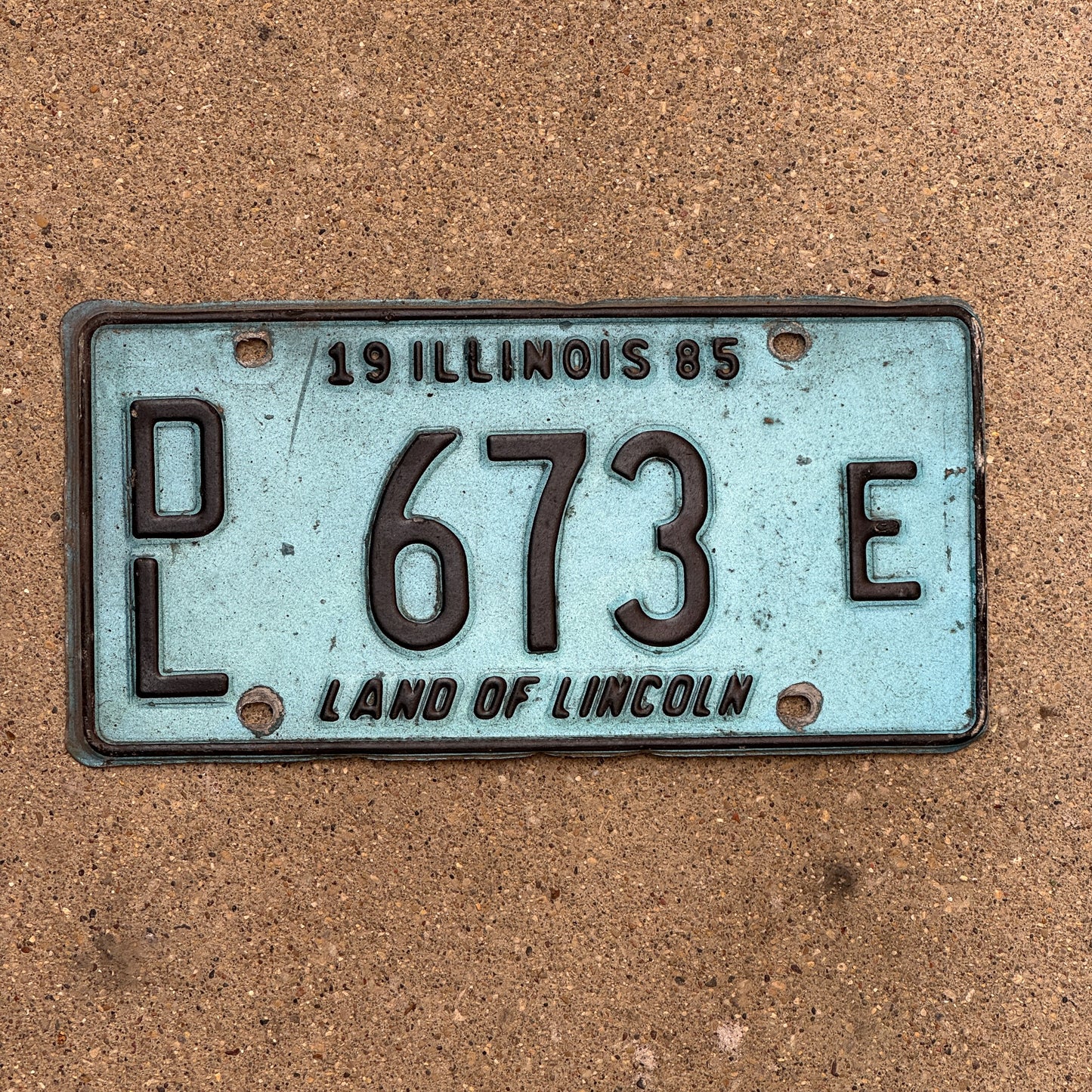 Photo of a 1985 Illinois Dealer License Plate Auto Tag 1 Vintage Garage Merritt's Sterling Ford Mercury Lincoln Dealer 673 E with original patina