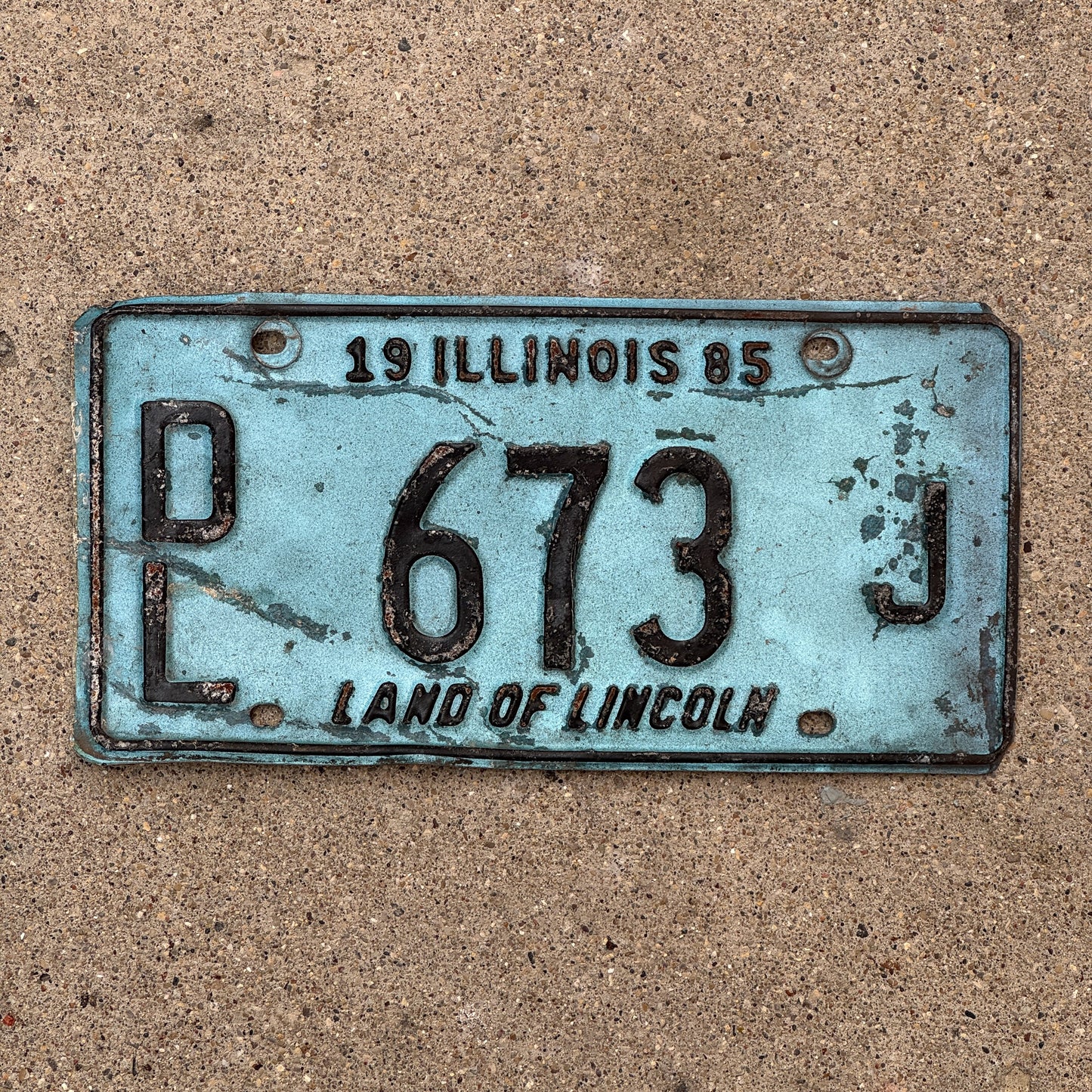 Photo of a 1985 Illinois Dealer License Plate Auto Tag 1 Vintage Garage Merritt's Sterling Ford Mercury Lincoln Dealer 673 J with original patina