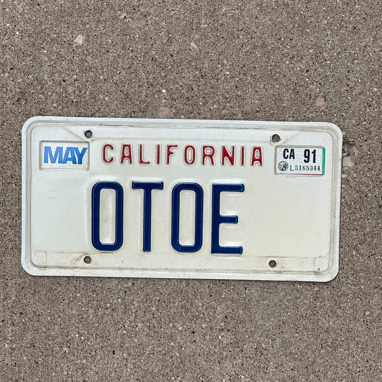 Photo of a 1987 1991 California Vanity License Plate Auto Tag Garage Decor Vintage Native American Indian Tribe OTOE with original patina