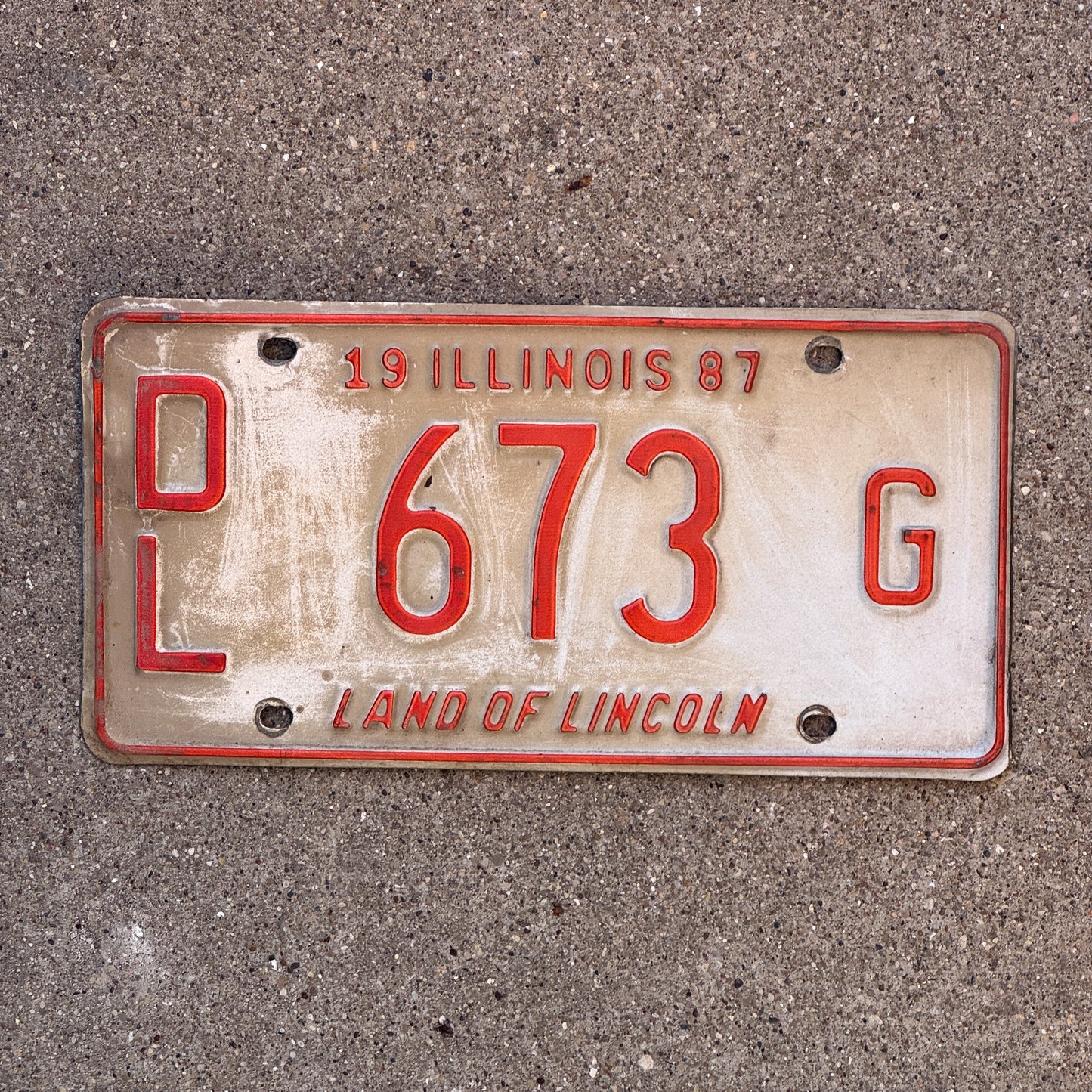 Photo of a 1987 Illinois Dealer License Plate Auto Tag 1 Vintage Garage Merritt's Sterling Ford Mercury Lincoln Dealer 673 G with original patina