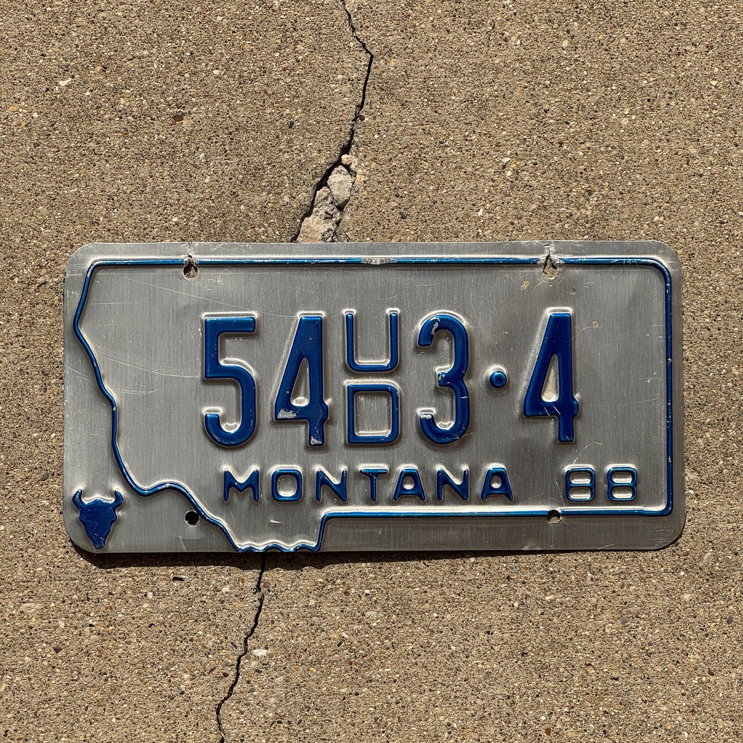 Photo of a 1988 Montana Dealer License Plate Auto Tag Garage Decor Vintage 54 UD 3 4