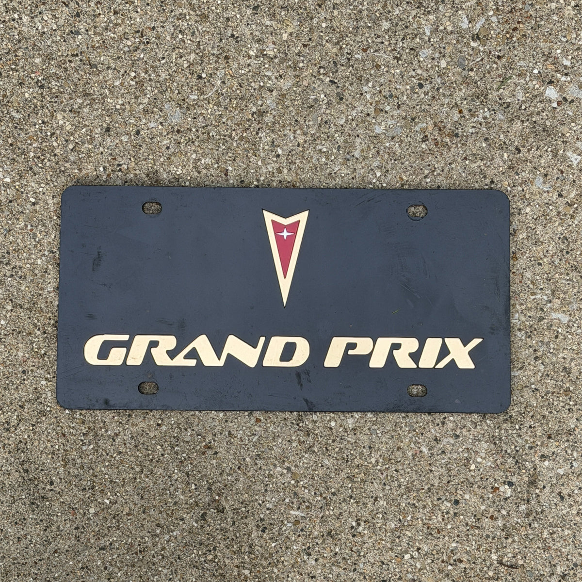 Photo of a 1990 Era Booster License Plate Auto Tag Garage Decor Vintage Pontiac Grand Prix Plastic with original patina