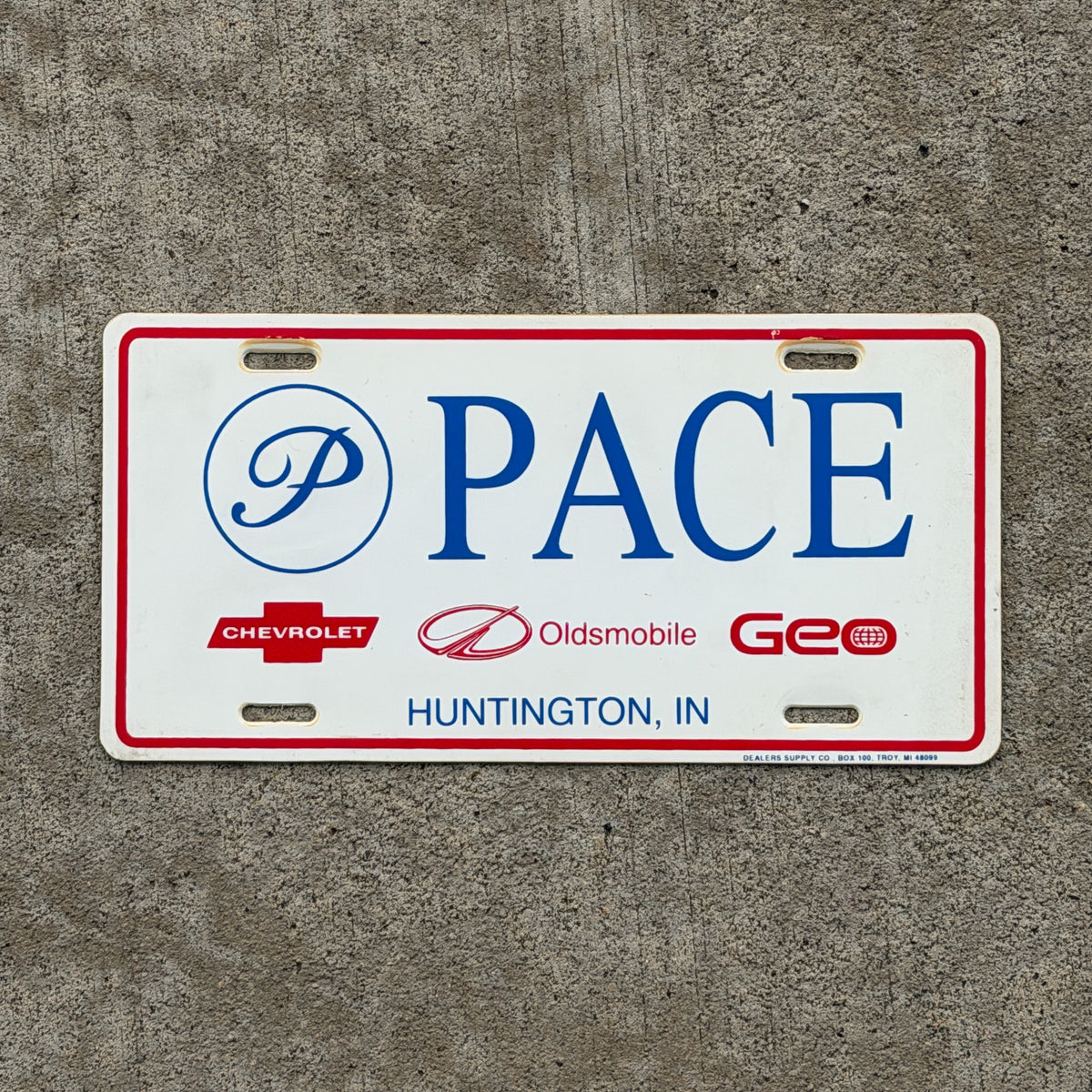 Photo of a 1990 Era Huntington Indiana Booster License Plate Auto Tag Garage Decor Vintage Pace Chevy Olds Geo Plastic with original patina
