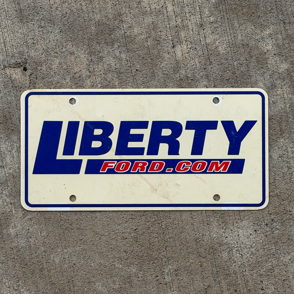 Photo of a 1990 Era Liberty Ford Booster License Plate Auto Tag Garage Decor Vintage Plastic with original patina